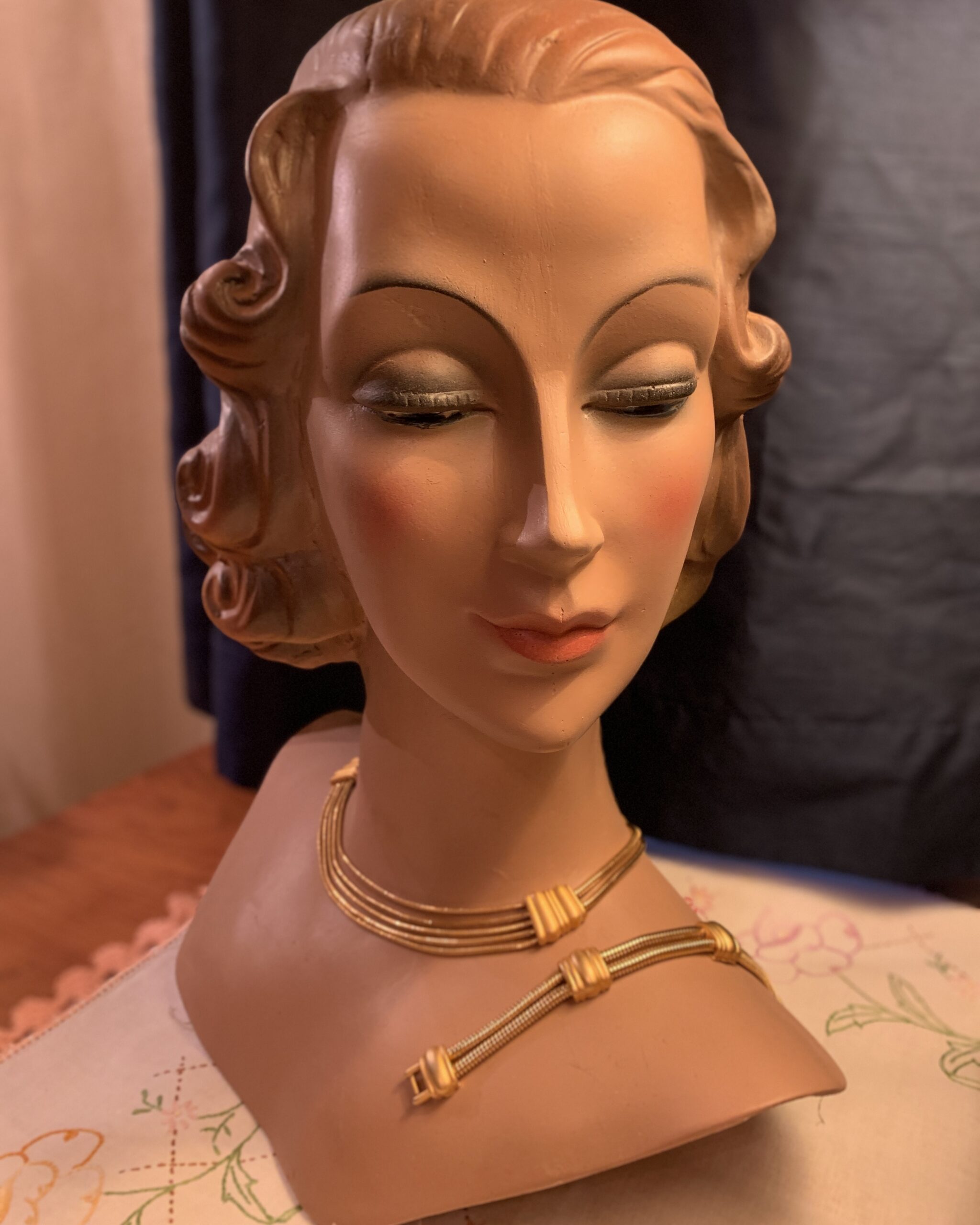 Vintage Monet gold multi-strand necklace and bracelet set displayed on mannequin bust, late 1980s–1990s gold-tone coordinated jewelry set.