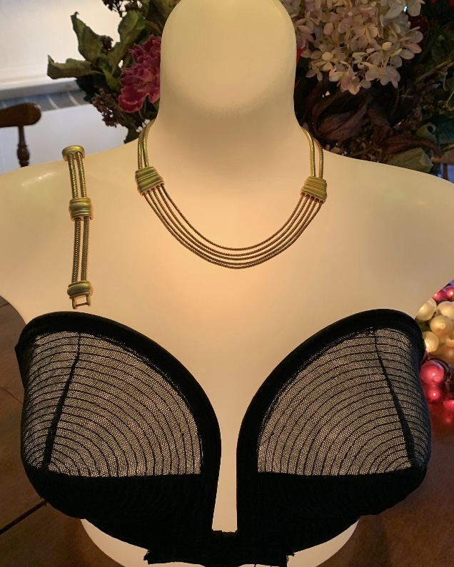 Vintage Monet modernist necklace and bracelet parure displayed on white bust with layered gold-tone snake chain design and sculptural spacer accents.