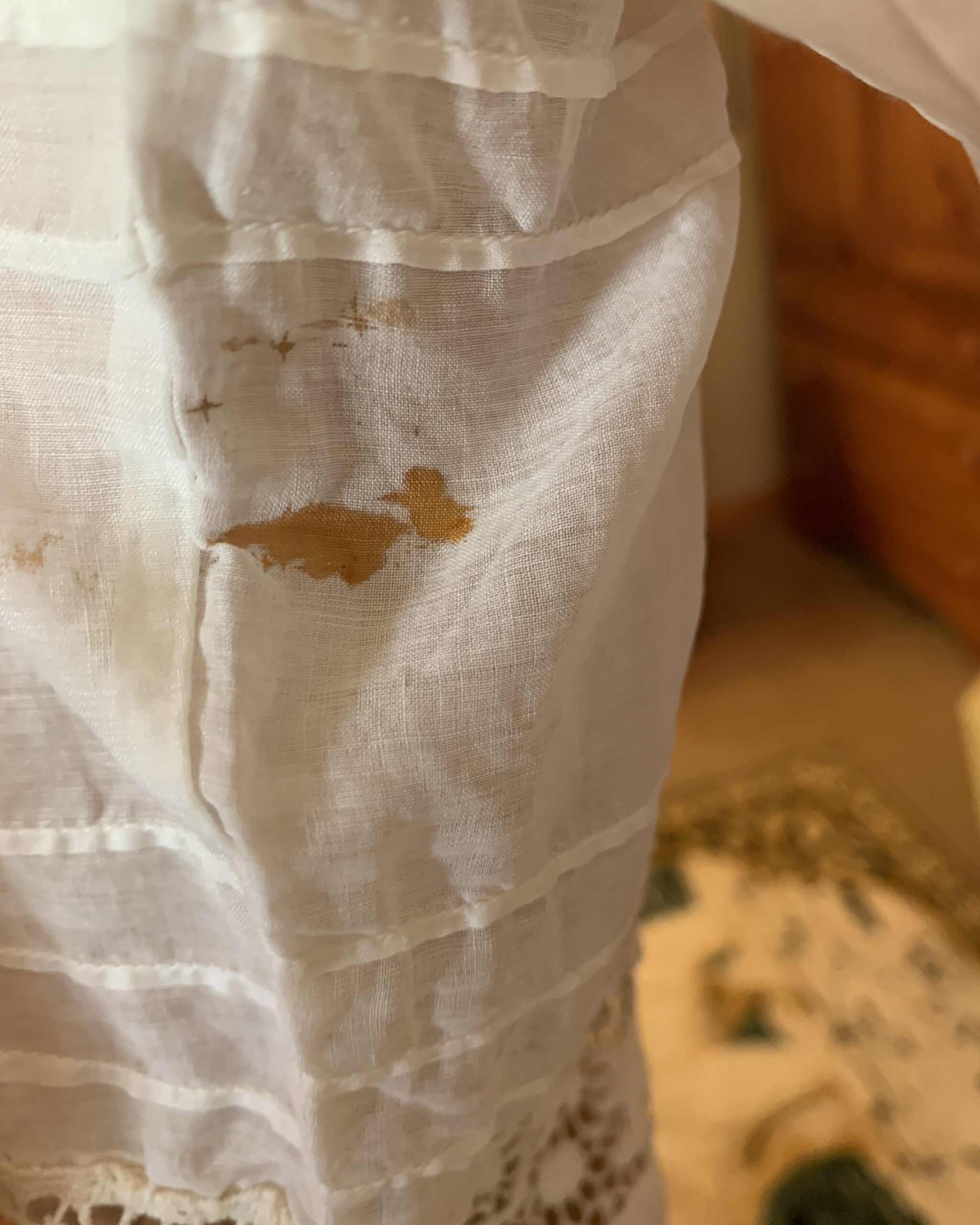 Interior sleeve condition detail showing a small age-related stain on an Edwardian white cotton day dress.