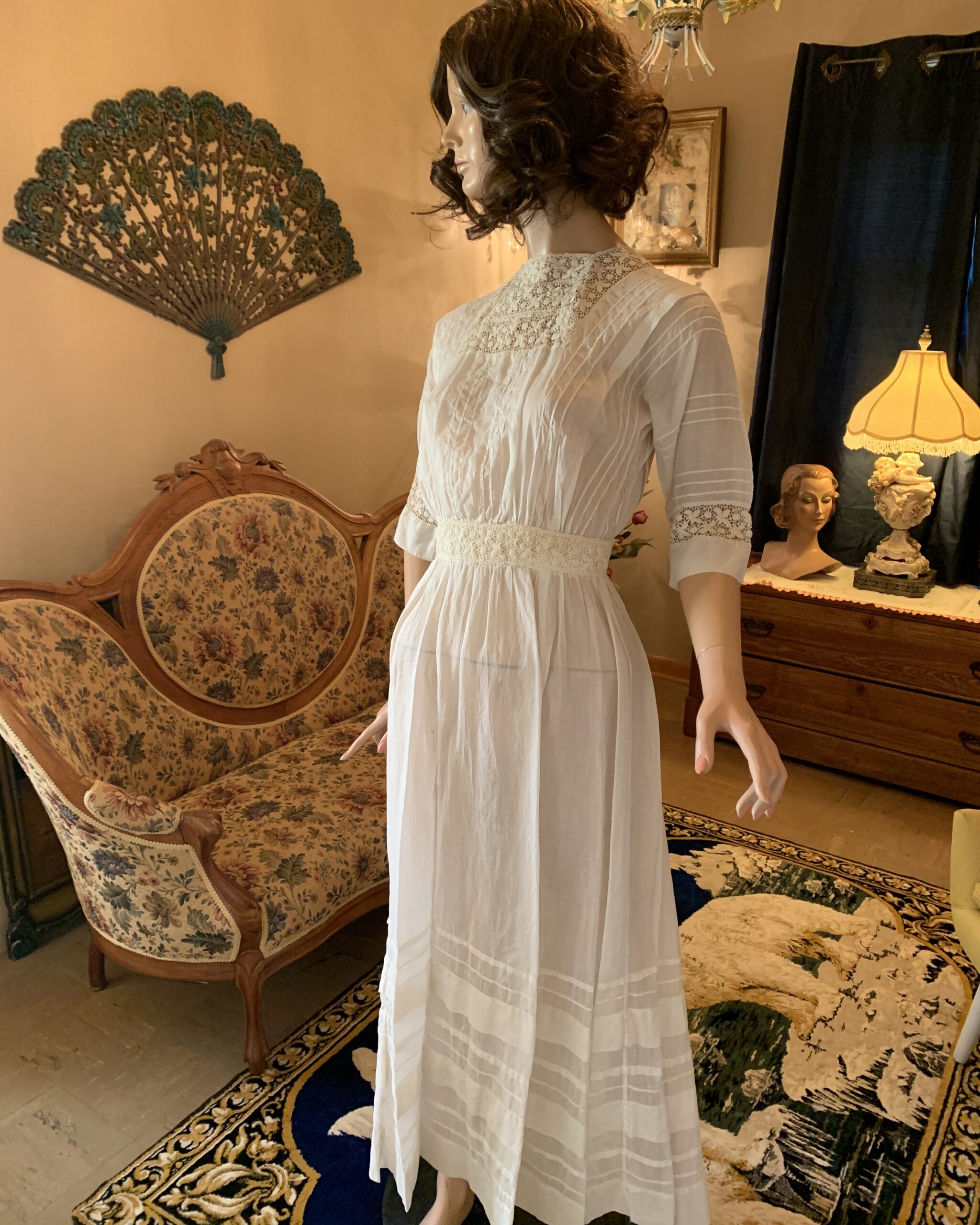 Edwardian white cotton day dress with lace yoke, pintucks, and lace waistband displayed on a mannequin, circa 1905–1912.