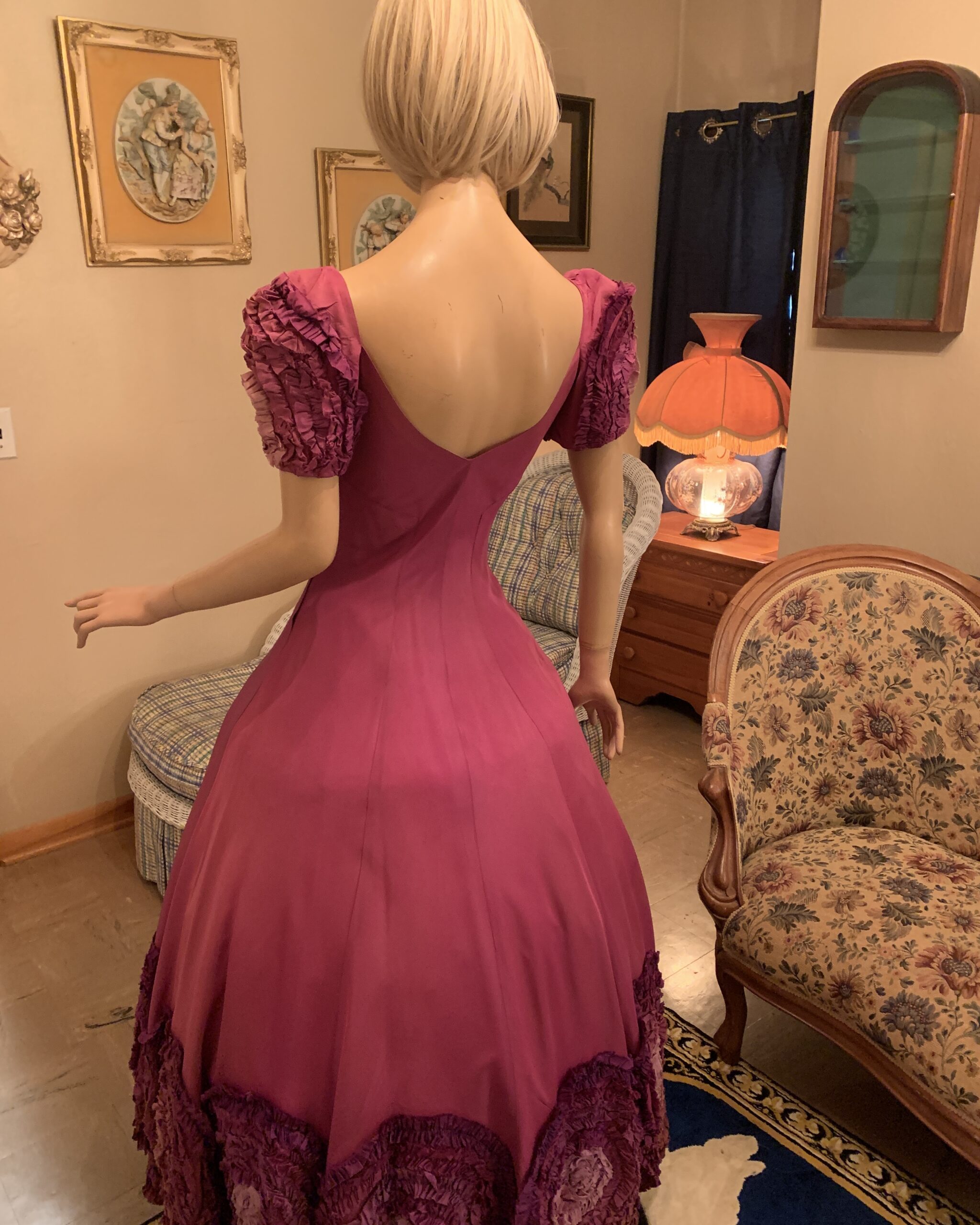 Back view of magenta vintage evening gown showing fitted waist, V-back neckline, and full sweeping skirt silhouette.