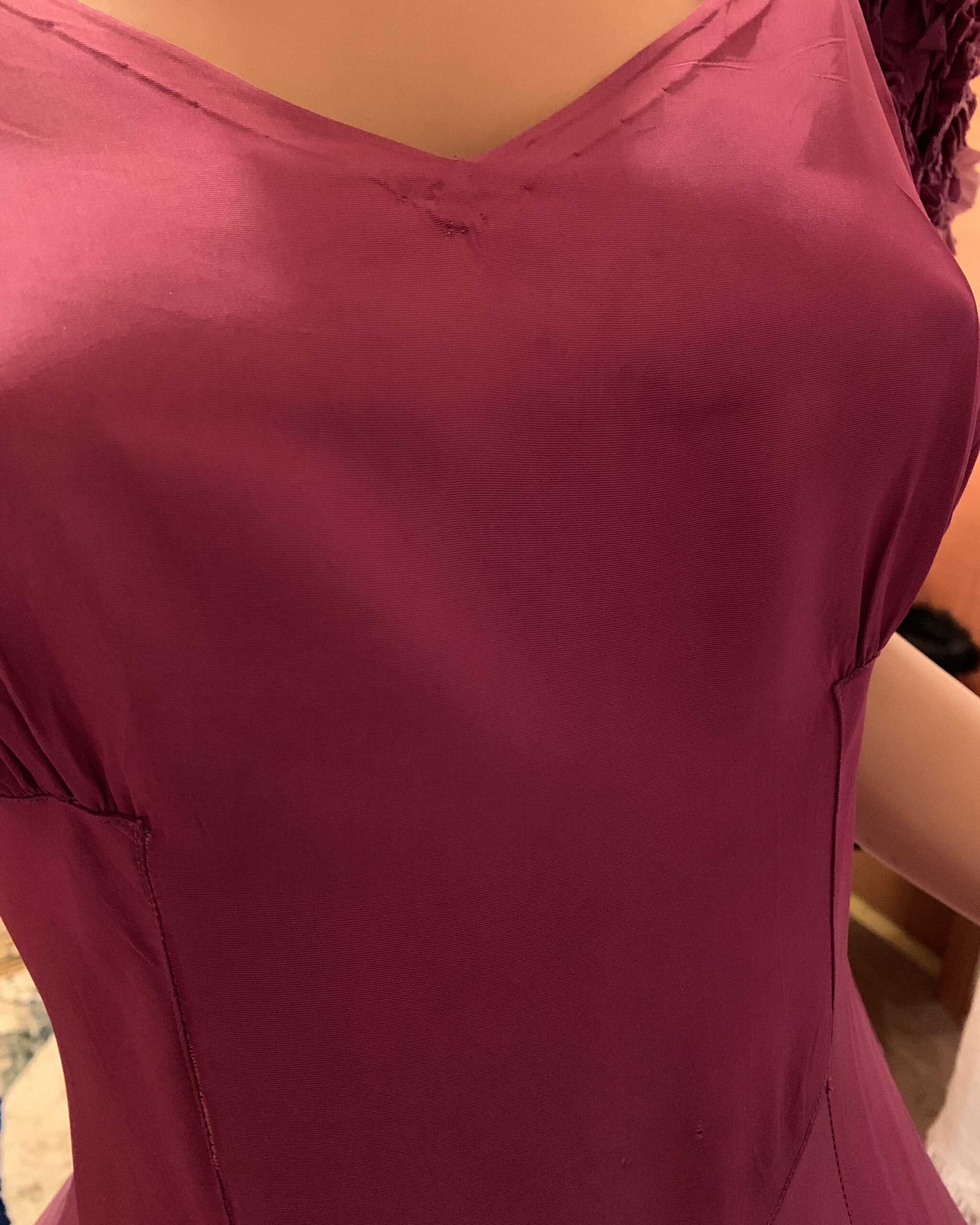 Close-up showing bodice condition detail on magenta vintage evening gown.