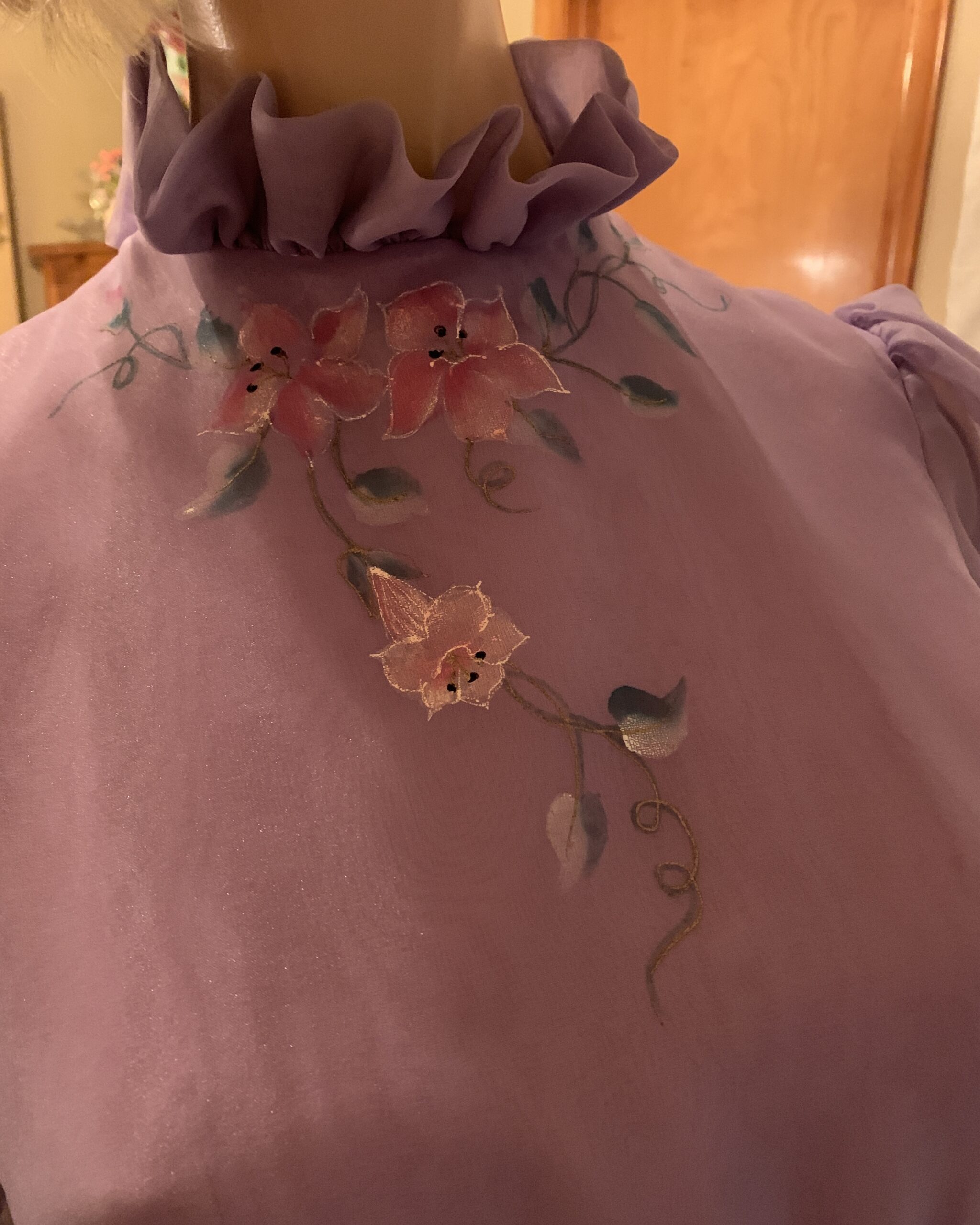Close-up of the hand-painted pink floral design decorating the ruffled high neckline of a vintage Elizabeth Arden lavender dress.