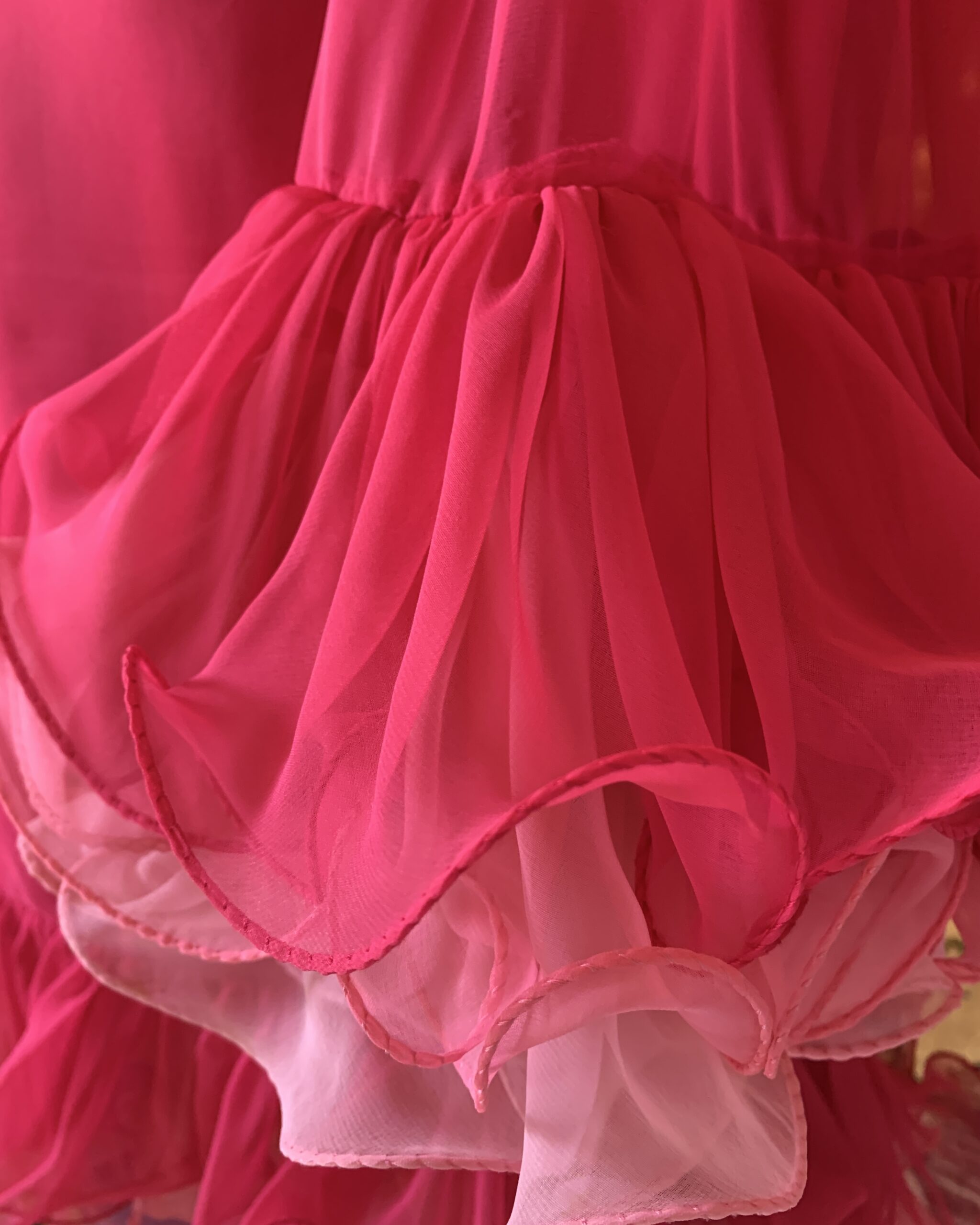 Detail of Miss Elliette hot pink chiffon ruffle hem with layered organza trim and wired edge finish