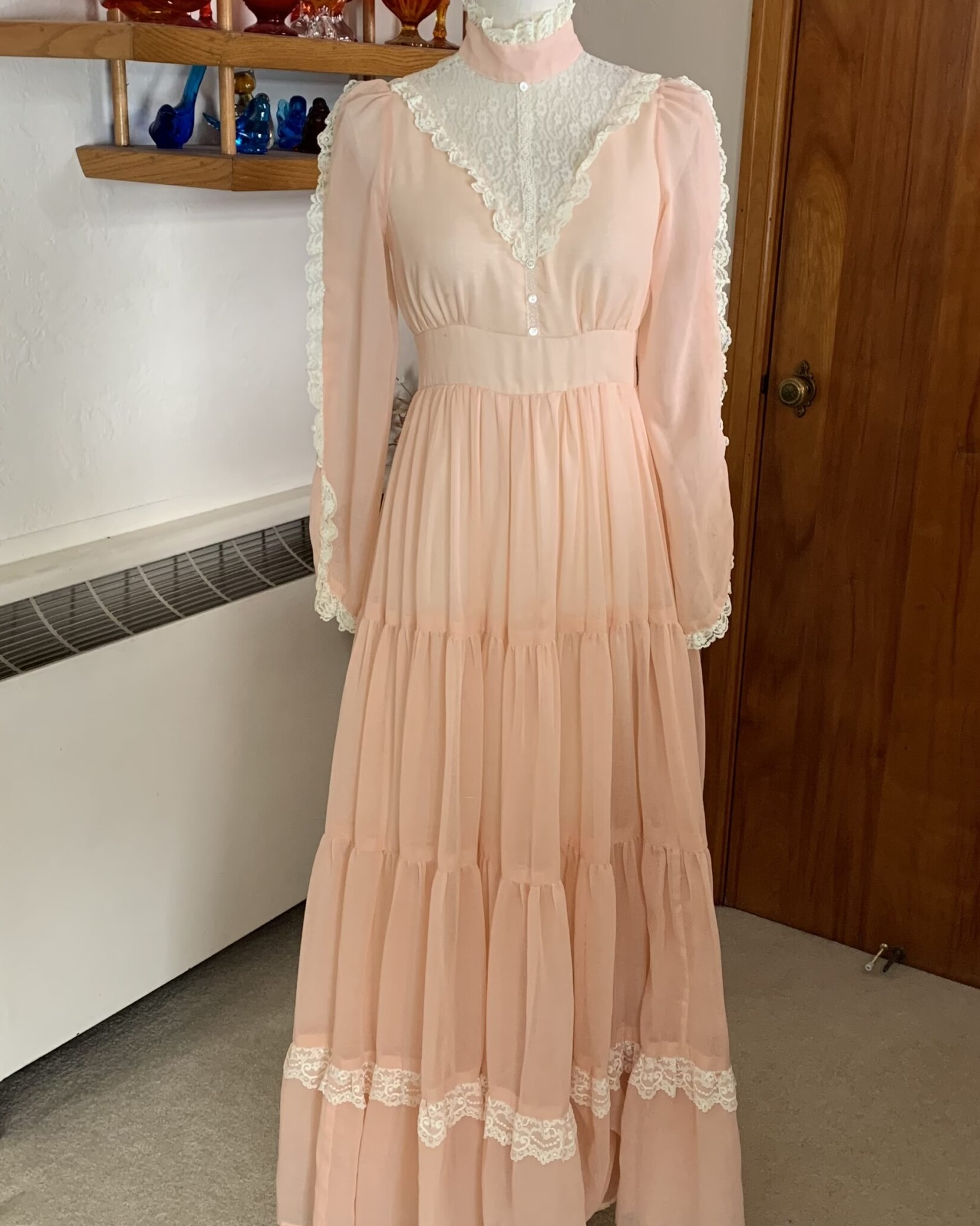 Front view of 1970s Gunne Sax by Jessica San Francisco peach prairie dress with lace bib yoke, high neckline, and tiered skirt.