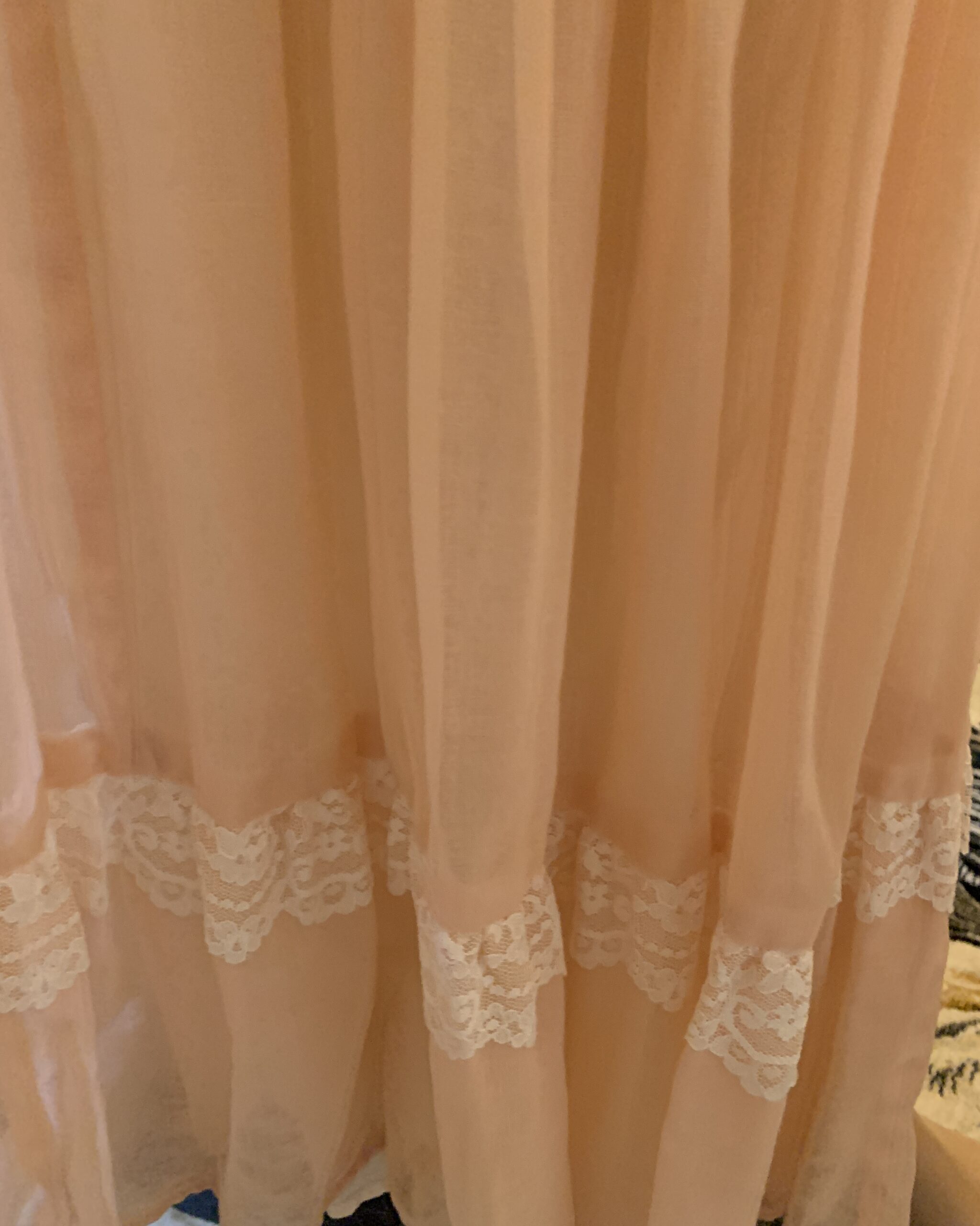 Close-up of lace insertion and tiered skirt detailing on a vintage Gunne Sax peach prairie dress.