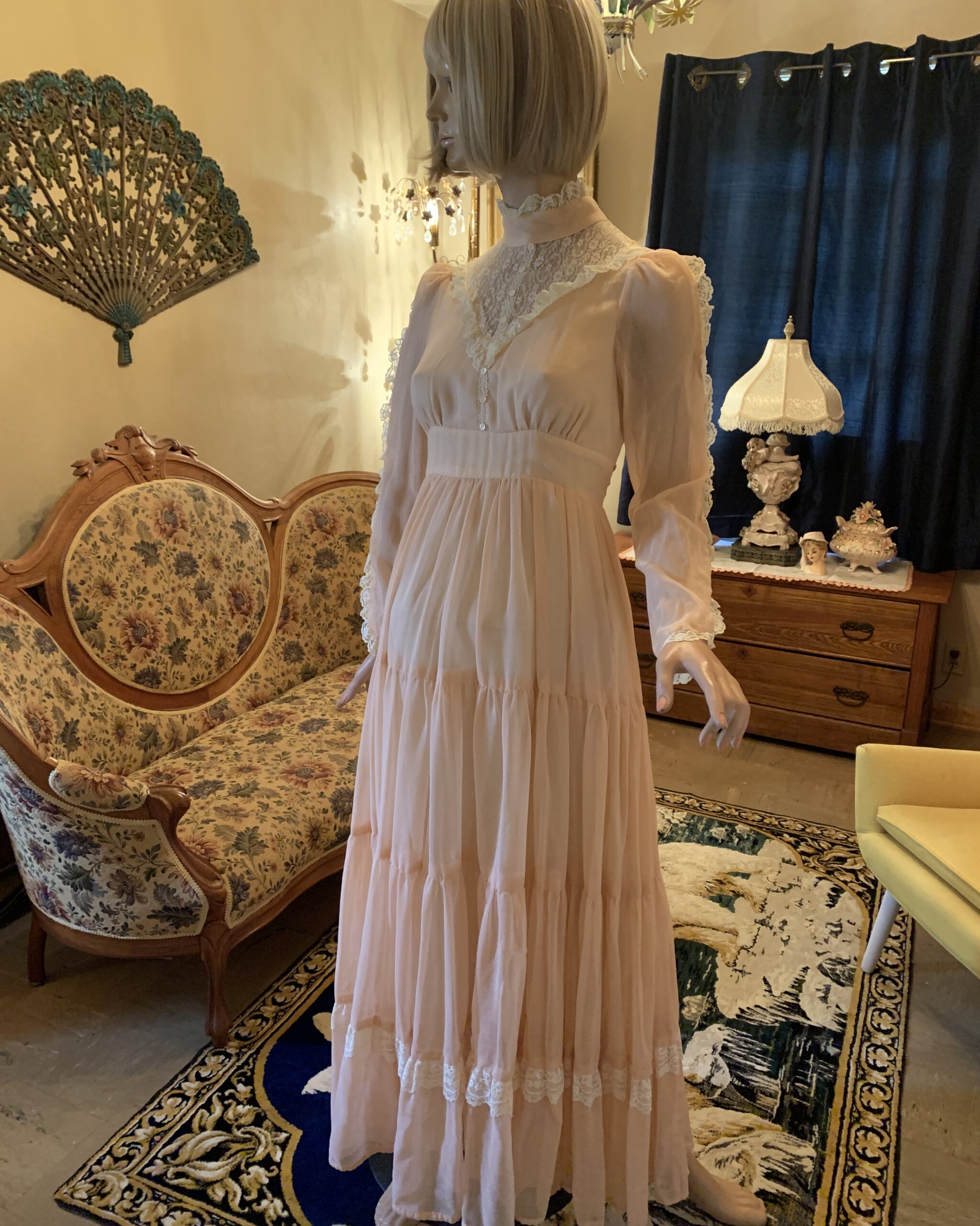 Side view of a vintage Gunne Sax peach prairie dress with soft drape, lace trim, and a flowing prairie-inspired skirt.