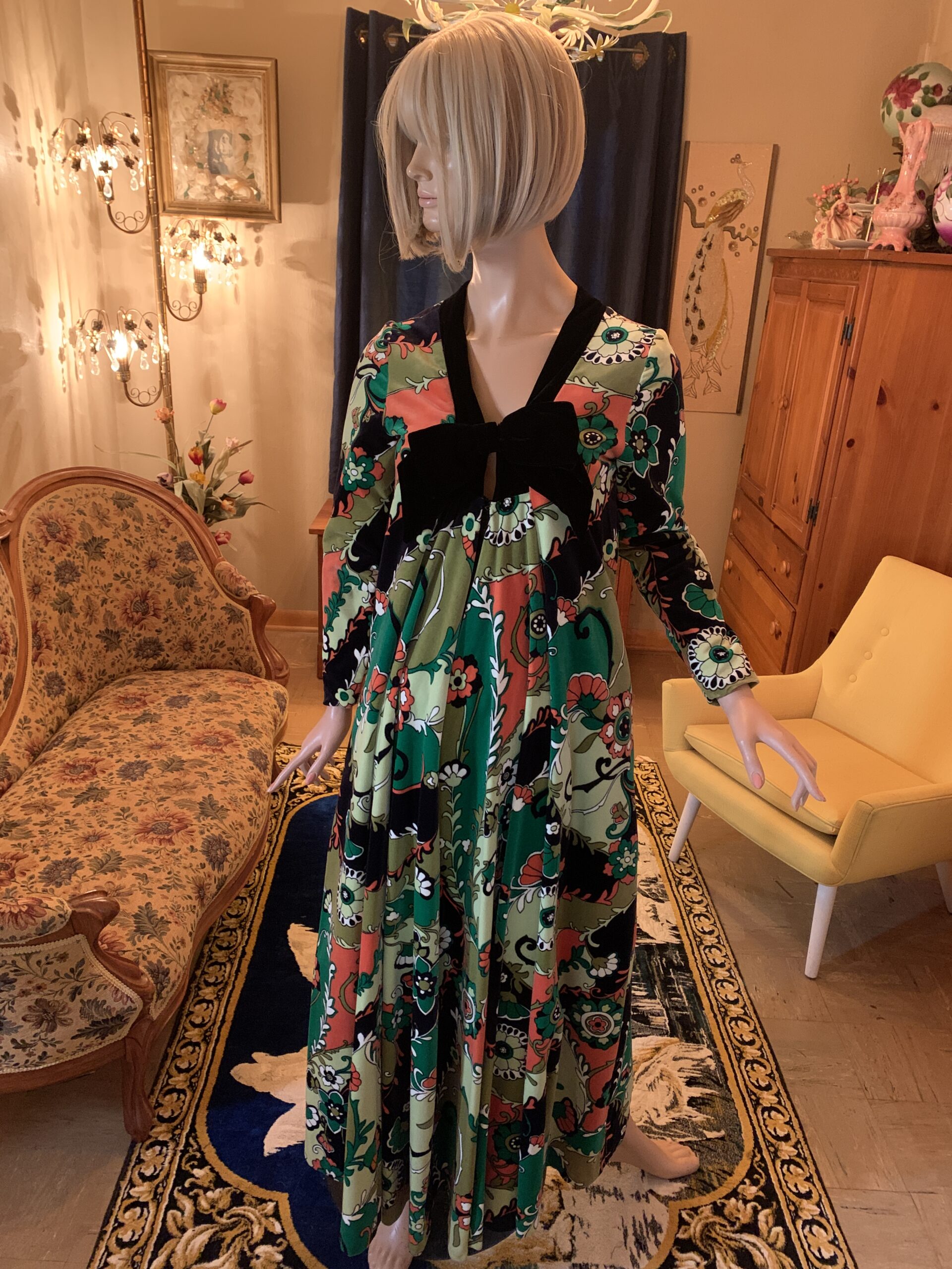 Front view of a vintage Bards Toronto floral maxi dress with a black velvet bow bodice, empire waist, long sleeves, and flowing full-length skirt.