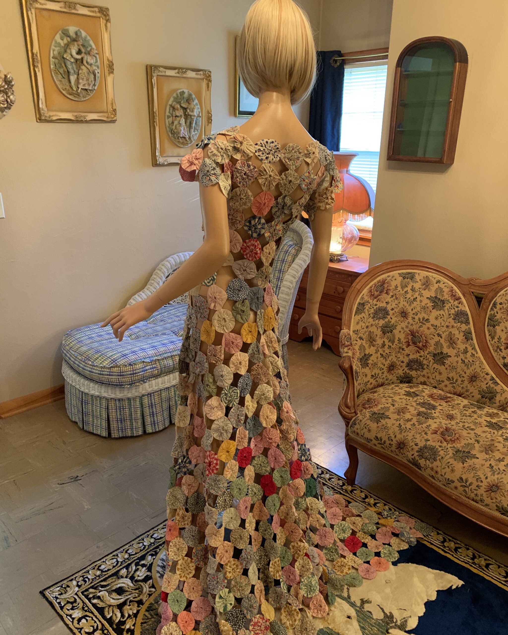 Back view of the handmade yo-yo quilt dress showing the lattice construction and cascading train of fabric yo-yos.