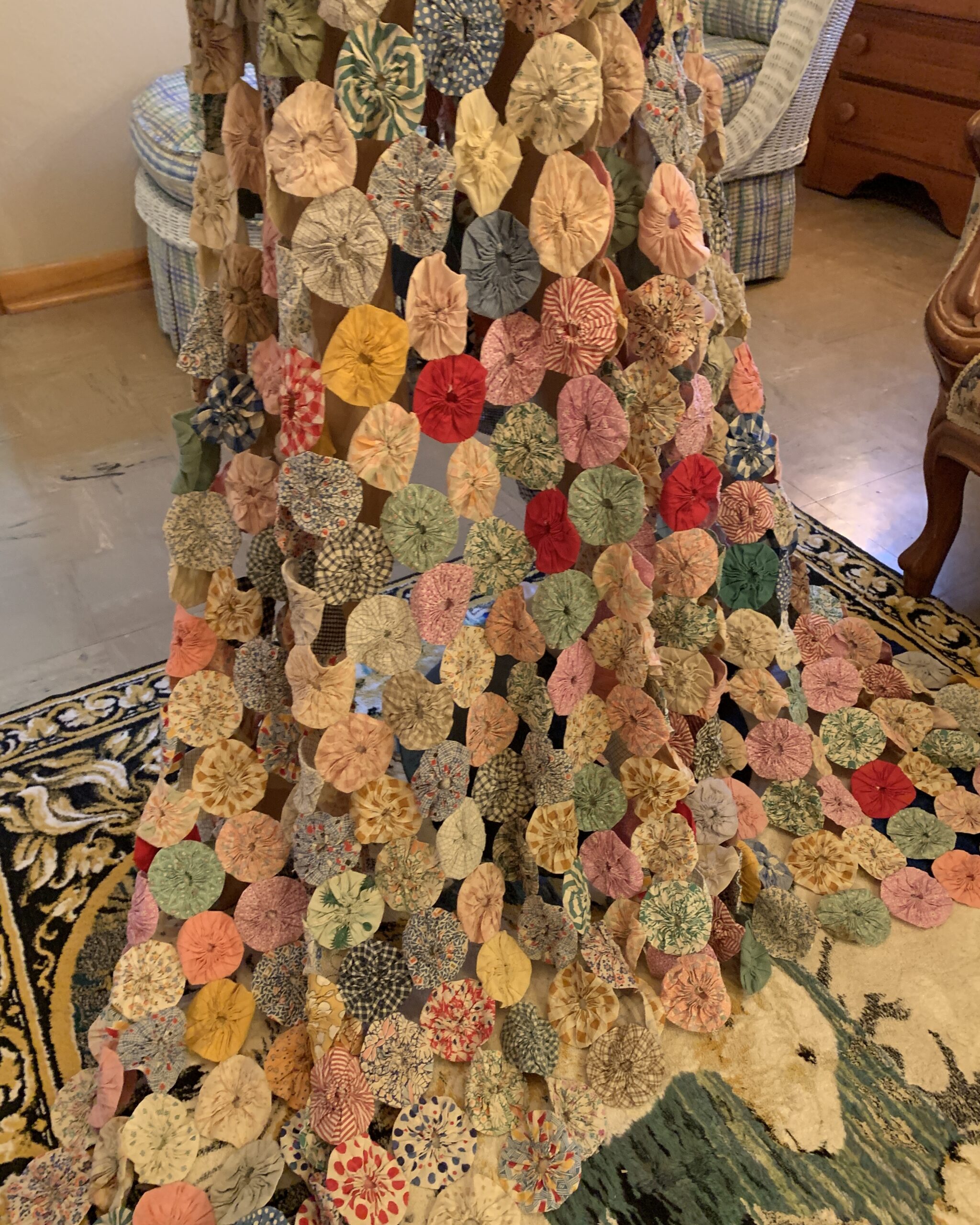 Detail of the skirt and train showing hundreds of handmade fabric yo-yos in floral, plaid, striped, and novelty prints.
