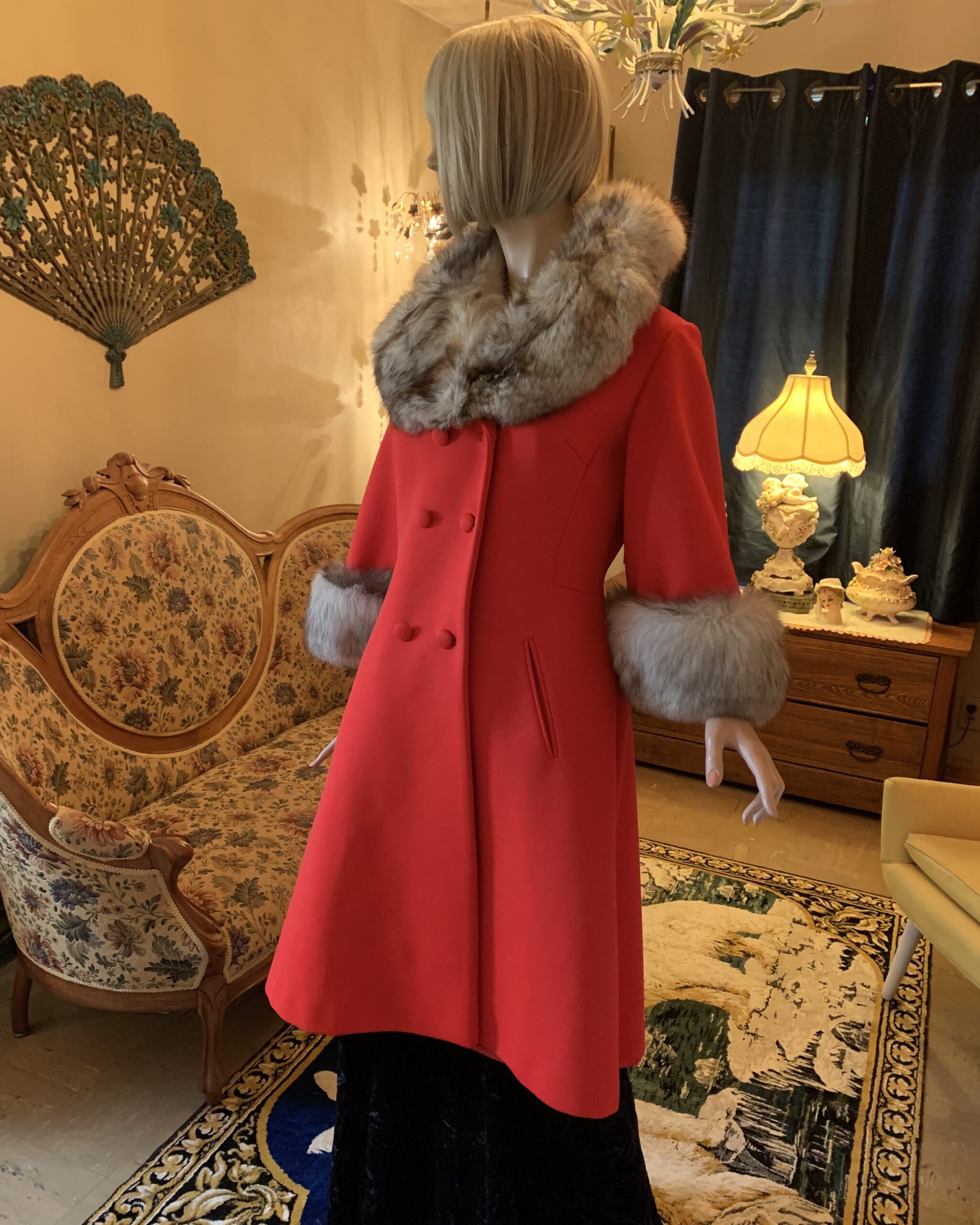 1960s Lilli Ann orange-red wool coat with genuine fox fur trim, shown from an angled front view highlighting the sweeping A-line silhouette.