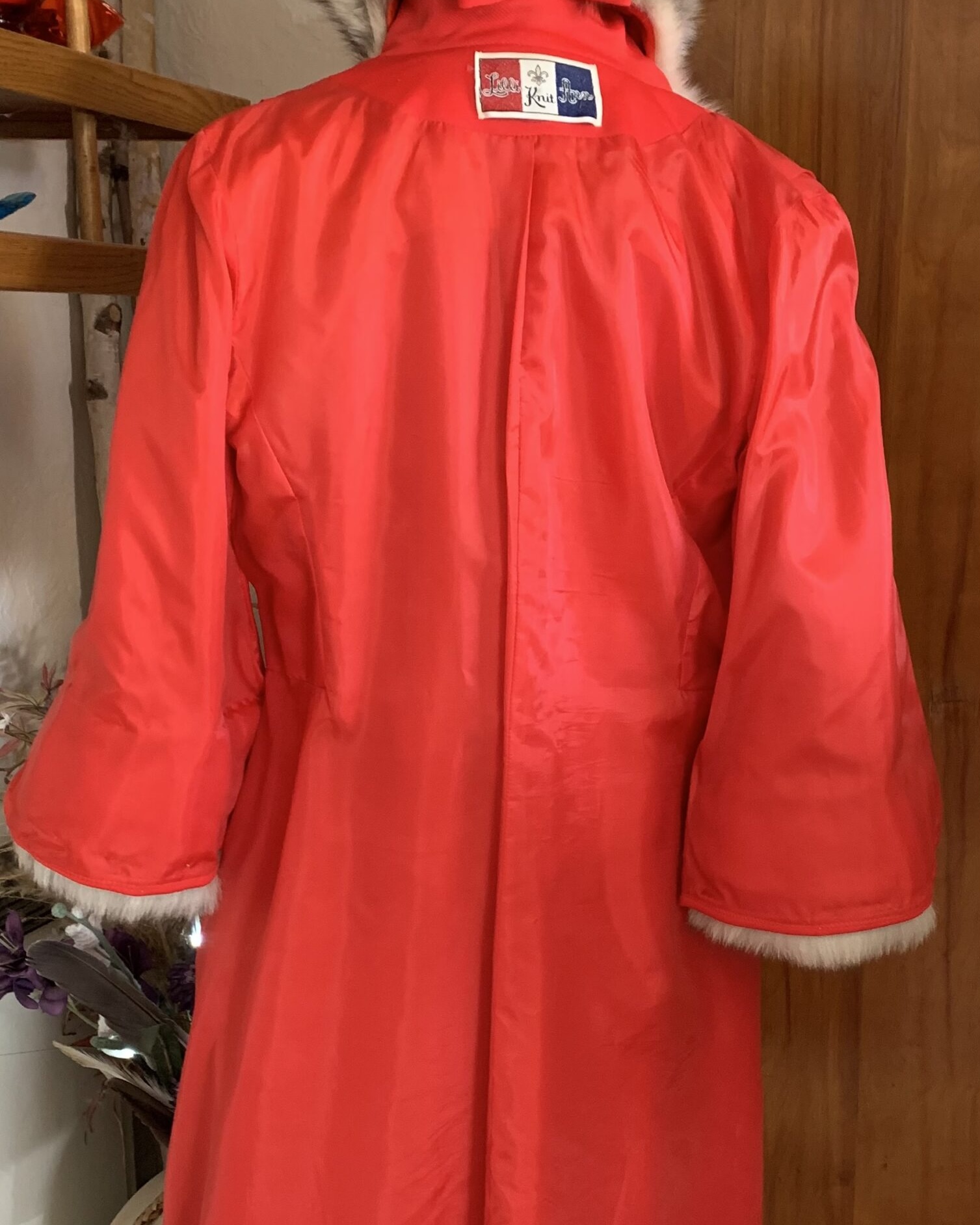 Bright red satin lining inside a vintage Lilli Ann wool coat, showing interior construction and condition.
