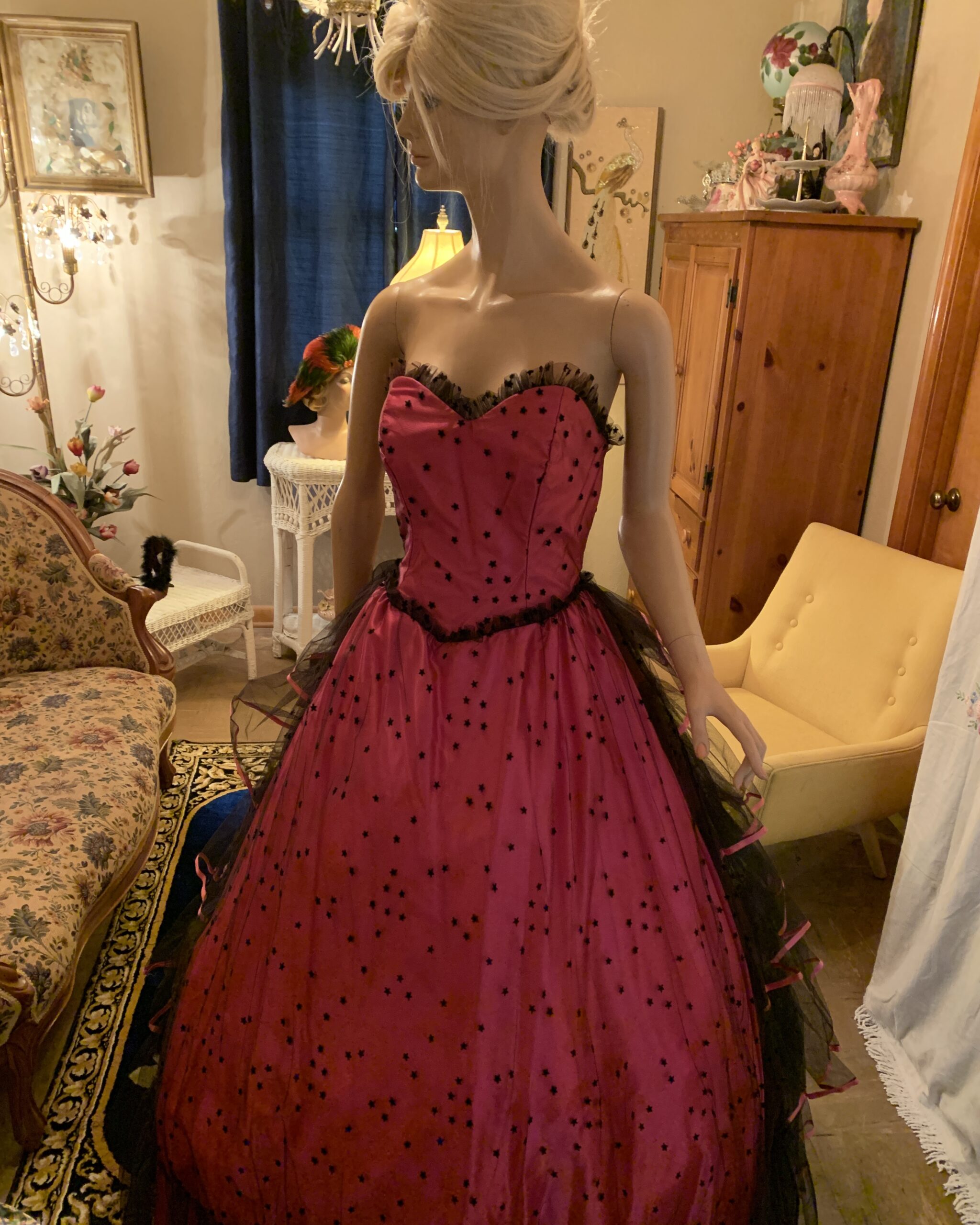 Front view of pink Alfred Angelo ball gown with sweetheart neckline, black star-patterned overlay, and full skirt.