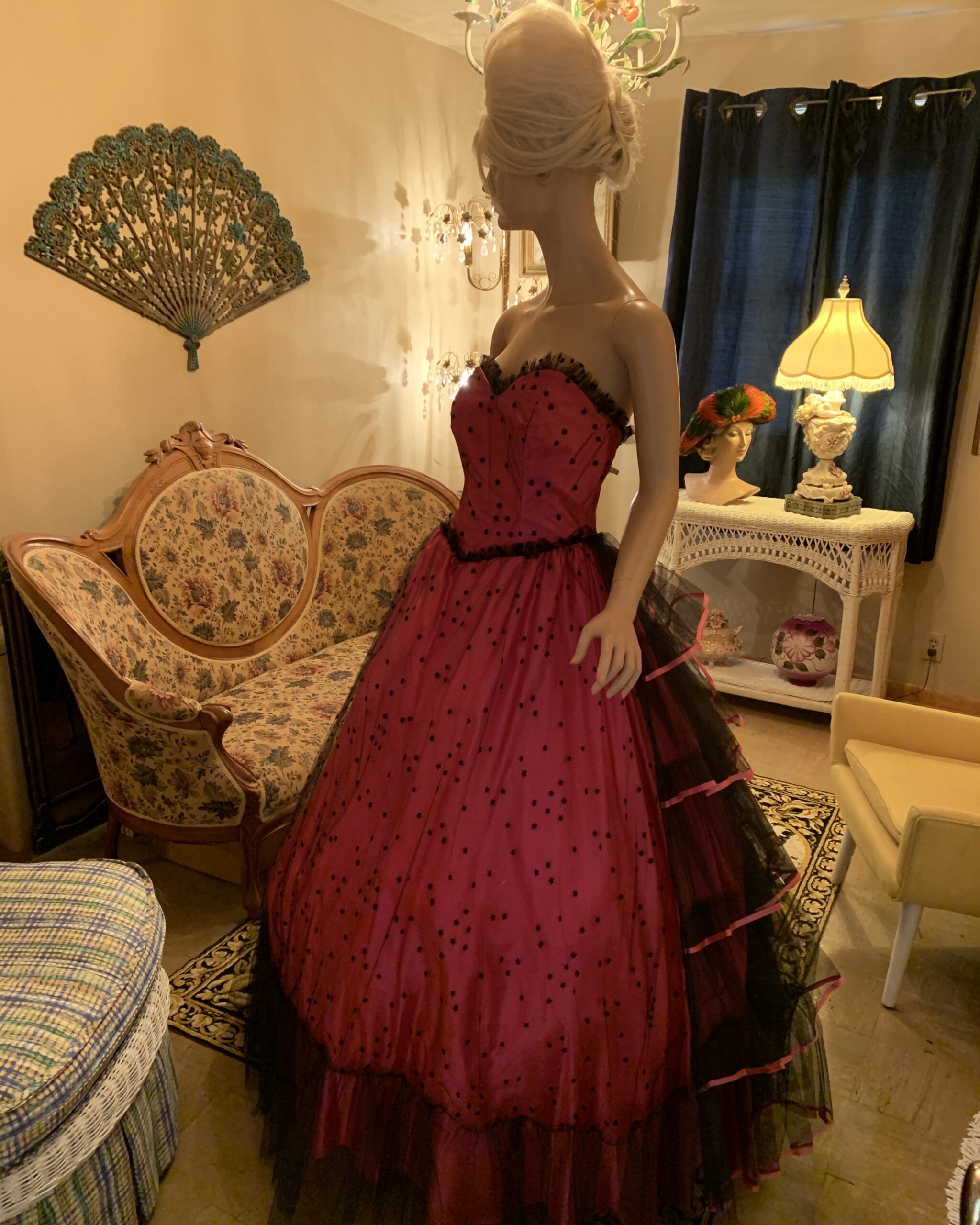 Side view of Flirtations by Alfred Angelo pink strapless gown with black star-patterned tulle and tiered skirt on a mannequin.