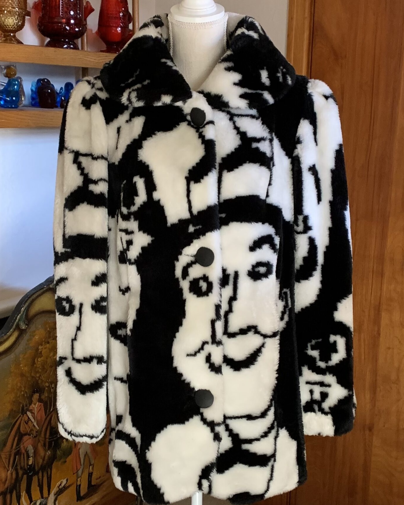 Black and white faux fur coat by Candace Originals featuring oversized abstract face motif, large collar, and button front closure.