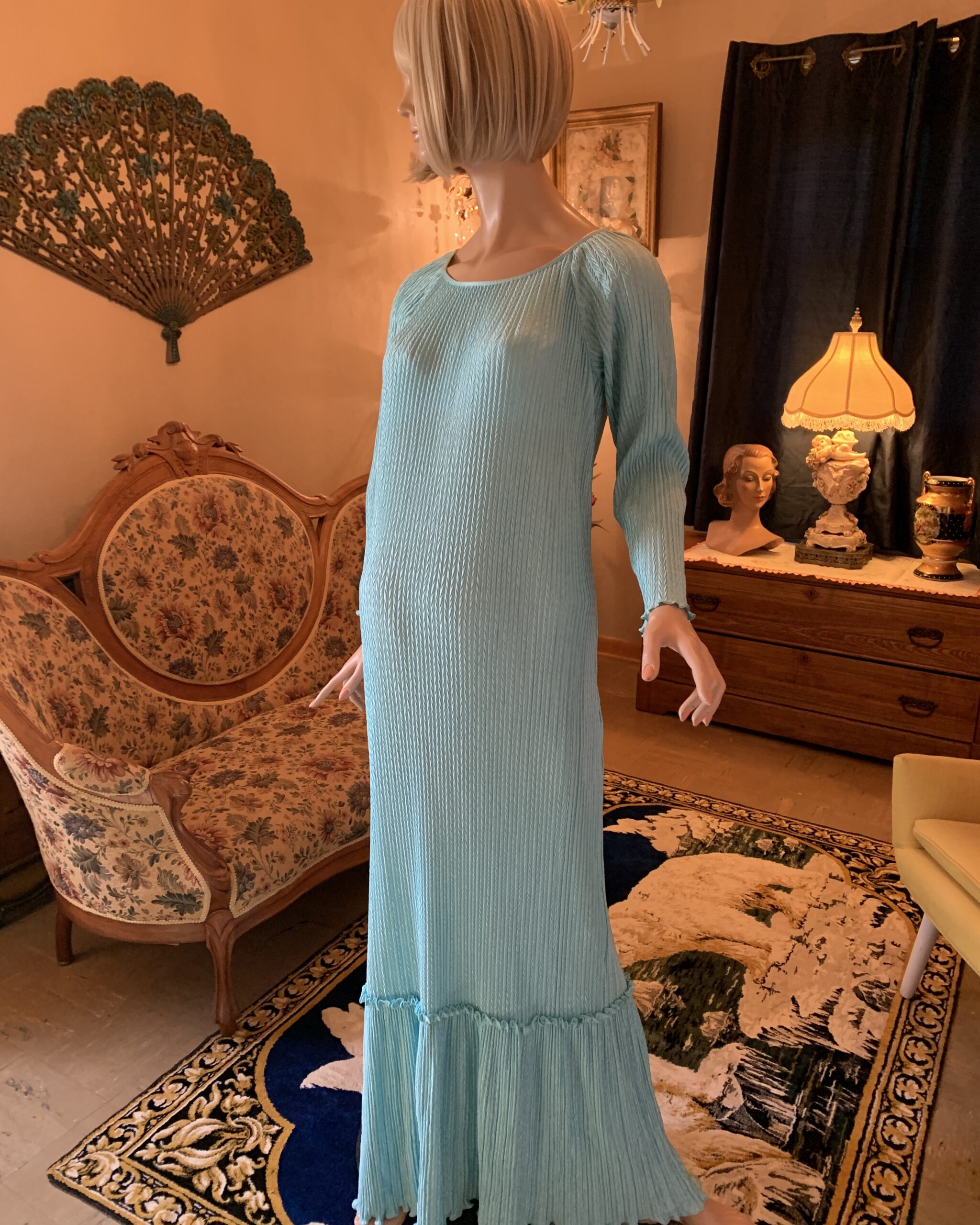 Mary McFadden Collection I aqua textured maxi dress with long sleeves and dimensional chevron knit pattern, front three-quarter view.