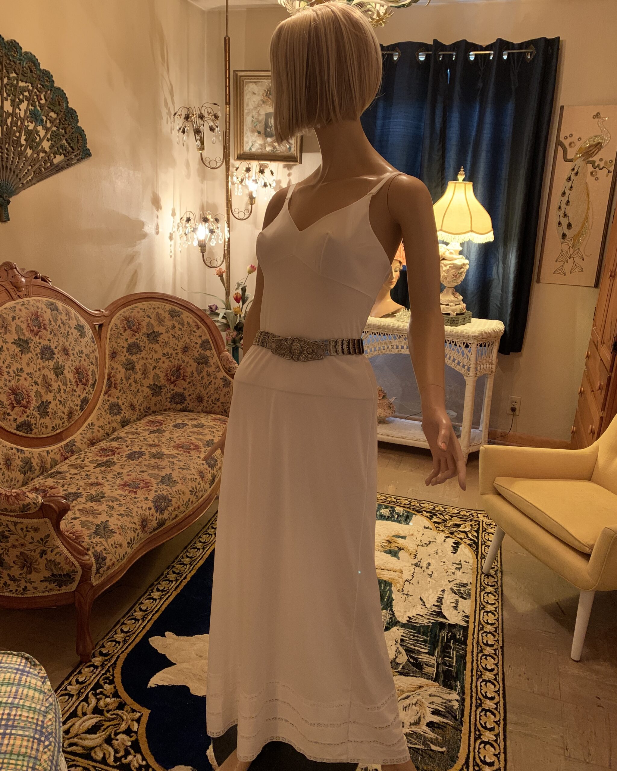 Vintage 1980s silver-tone articulated statement belt styled over a white slip dress on a mannequin.