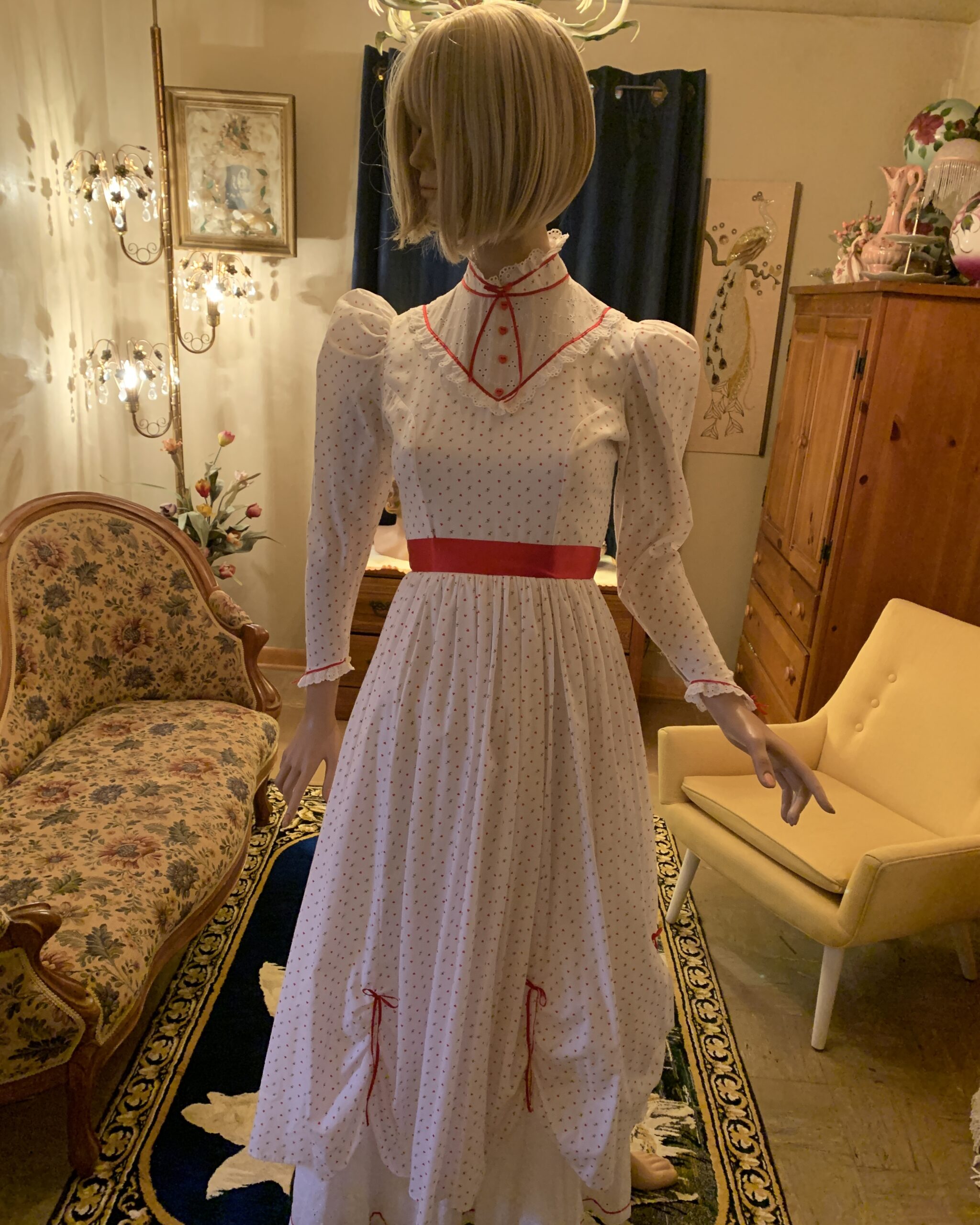Handmade vintage heart print prairie dress with red piping, puff sleeves, heart-shaped buttons, and a gathered skirt displayed on a mannequin.