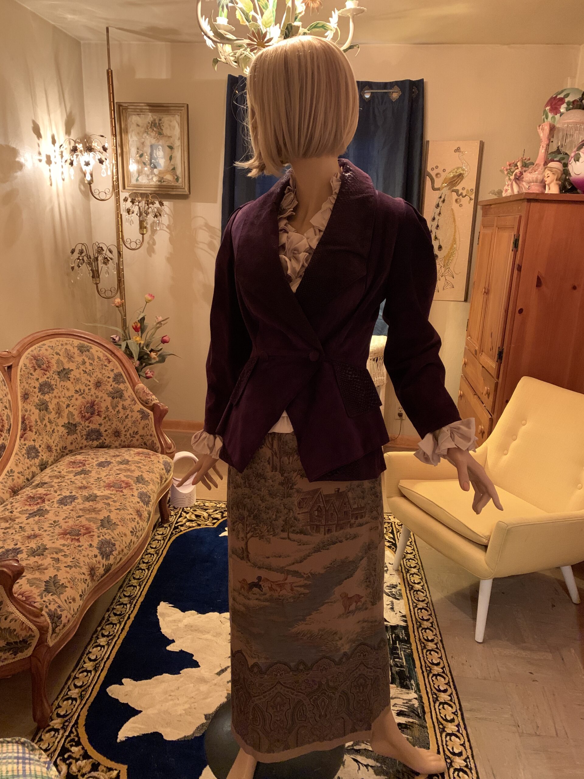 Vintage Danier aubergine suede leather jacket with snake embossed leather accents displayed with a ruffled blouse and scenic tapestry skirt.
