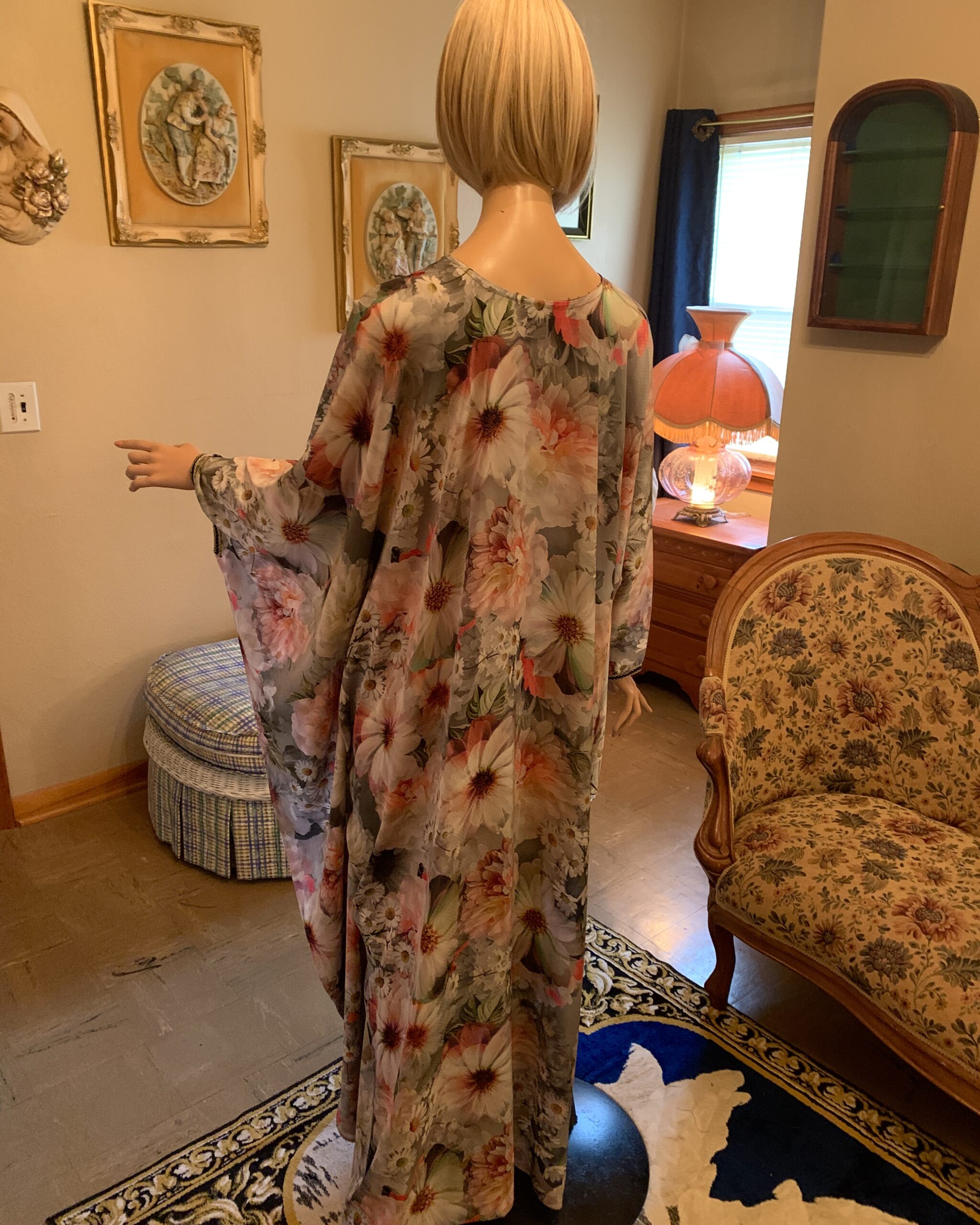 Back view of a vintage floral butterfly sleeve maxi dress featuring a sweeping full-length silhouette and oversized floral print.