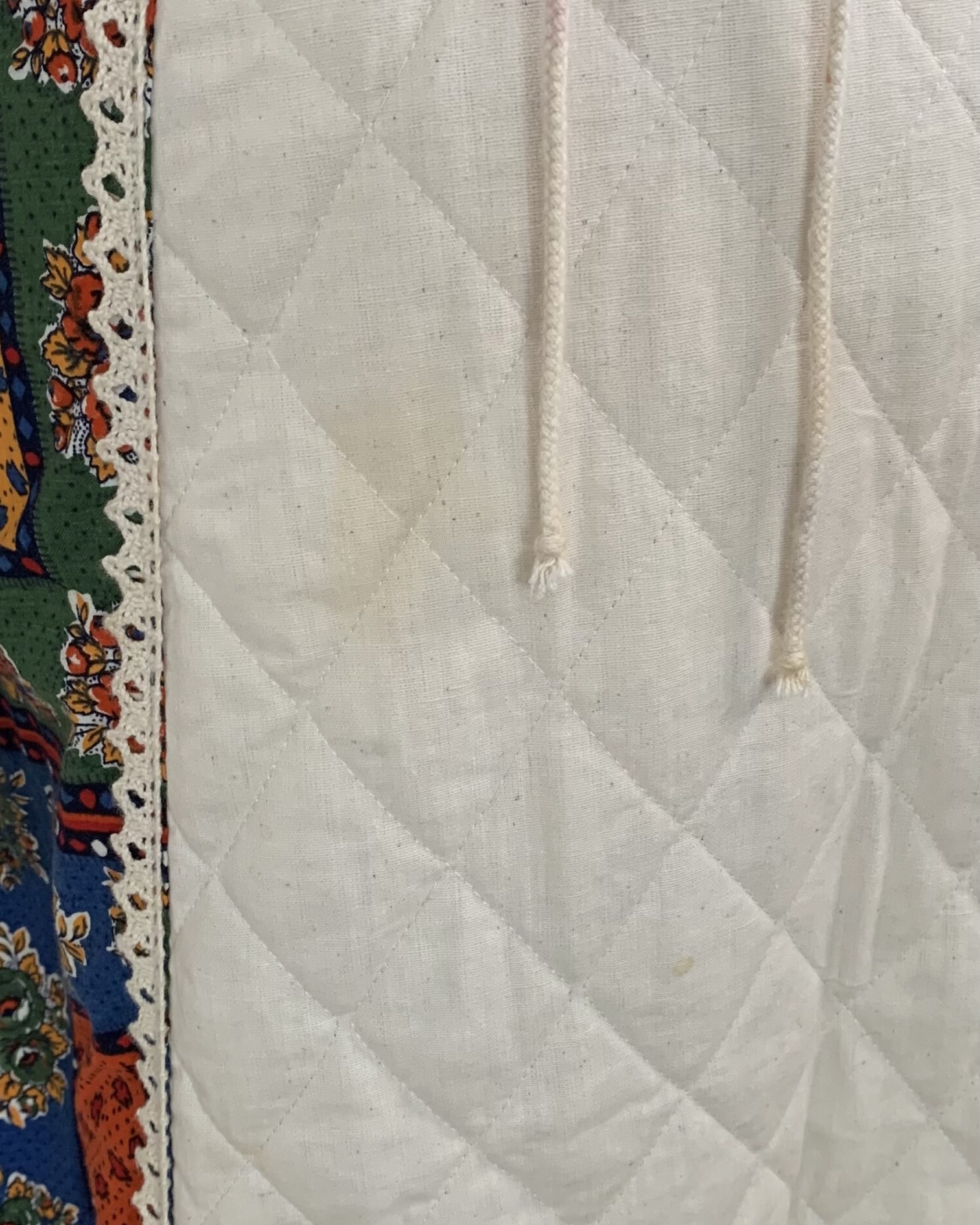 Close-up of quilted white apron panel with crochet trim on vintage Gunne Sax prairie dress