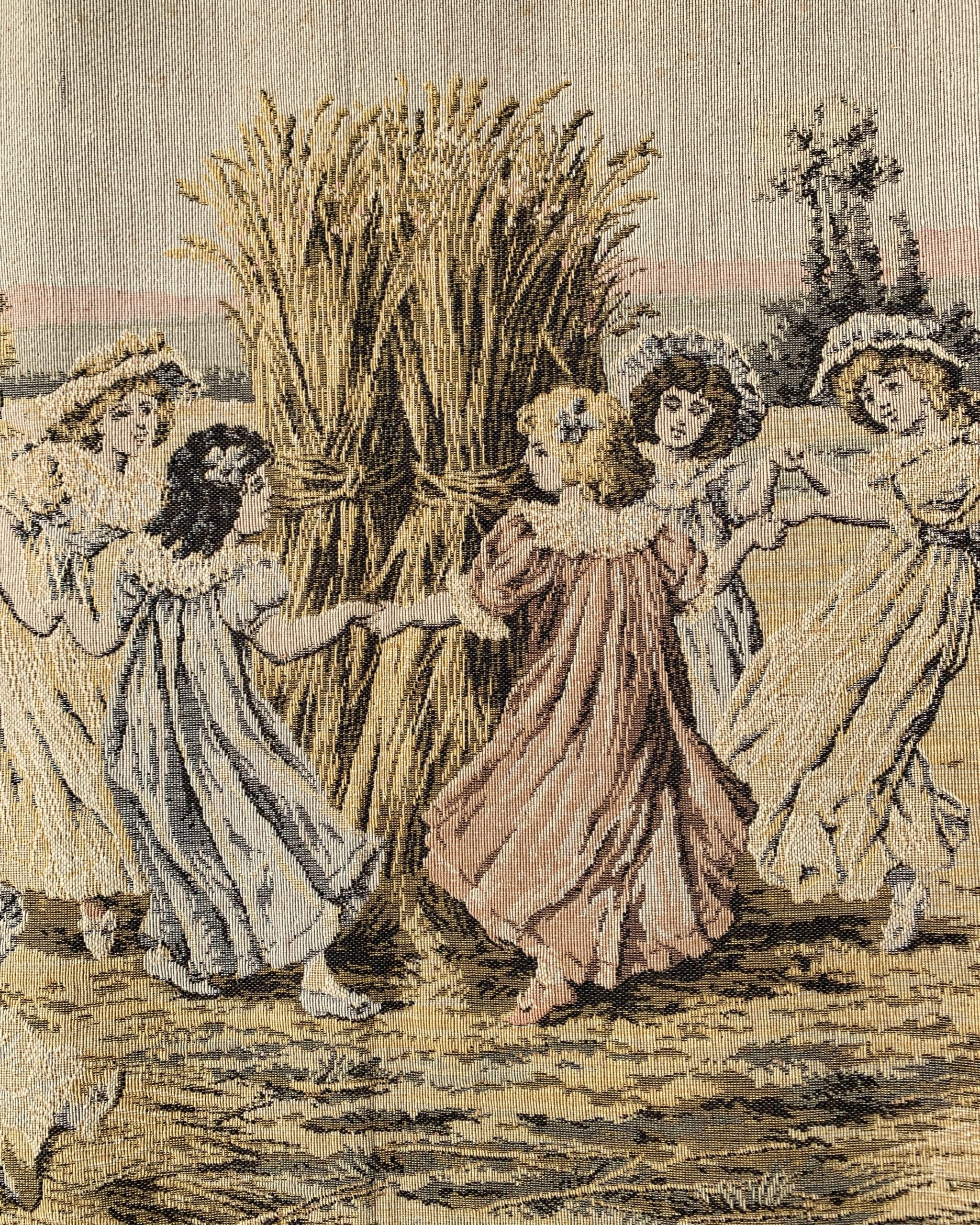 Close-up of woven tapestry depicting women dancing around a harvest sheaf in flowing dresses within a romantic pastoral landscape.