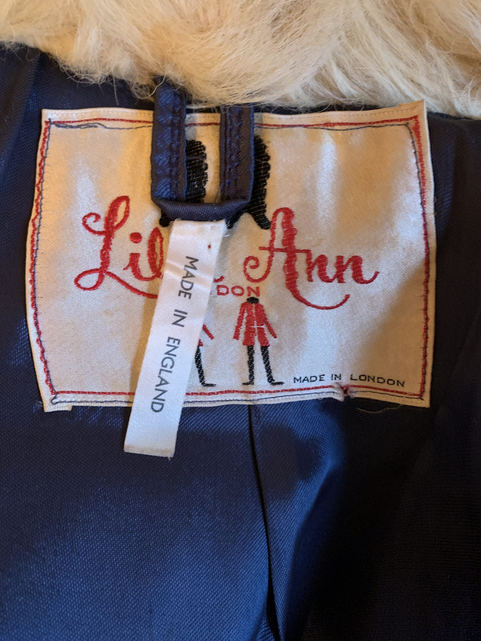 Lilli Ann Made in London label with Made in England tag inside a vintage purple shearling-trimmed coat.