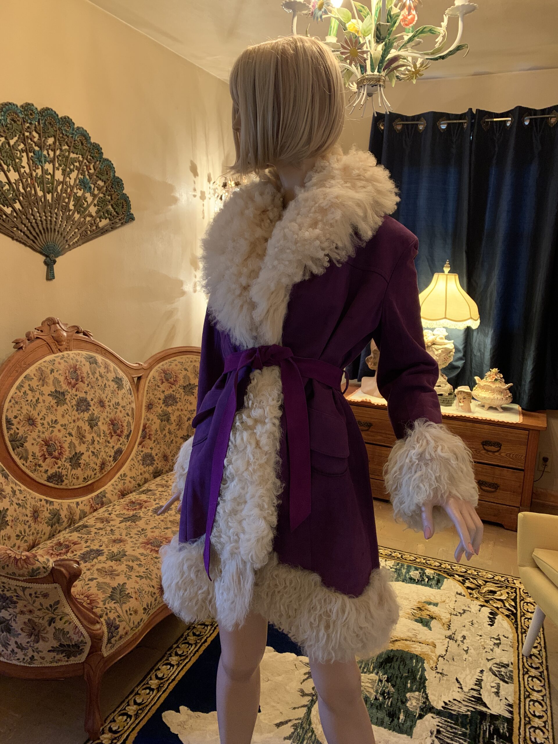 Vintage Lilli Ann purple coat with cream shearling trim and tie belt, shown from an angled view to highlight silhouette and drape.