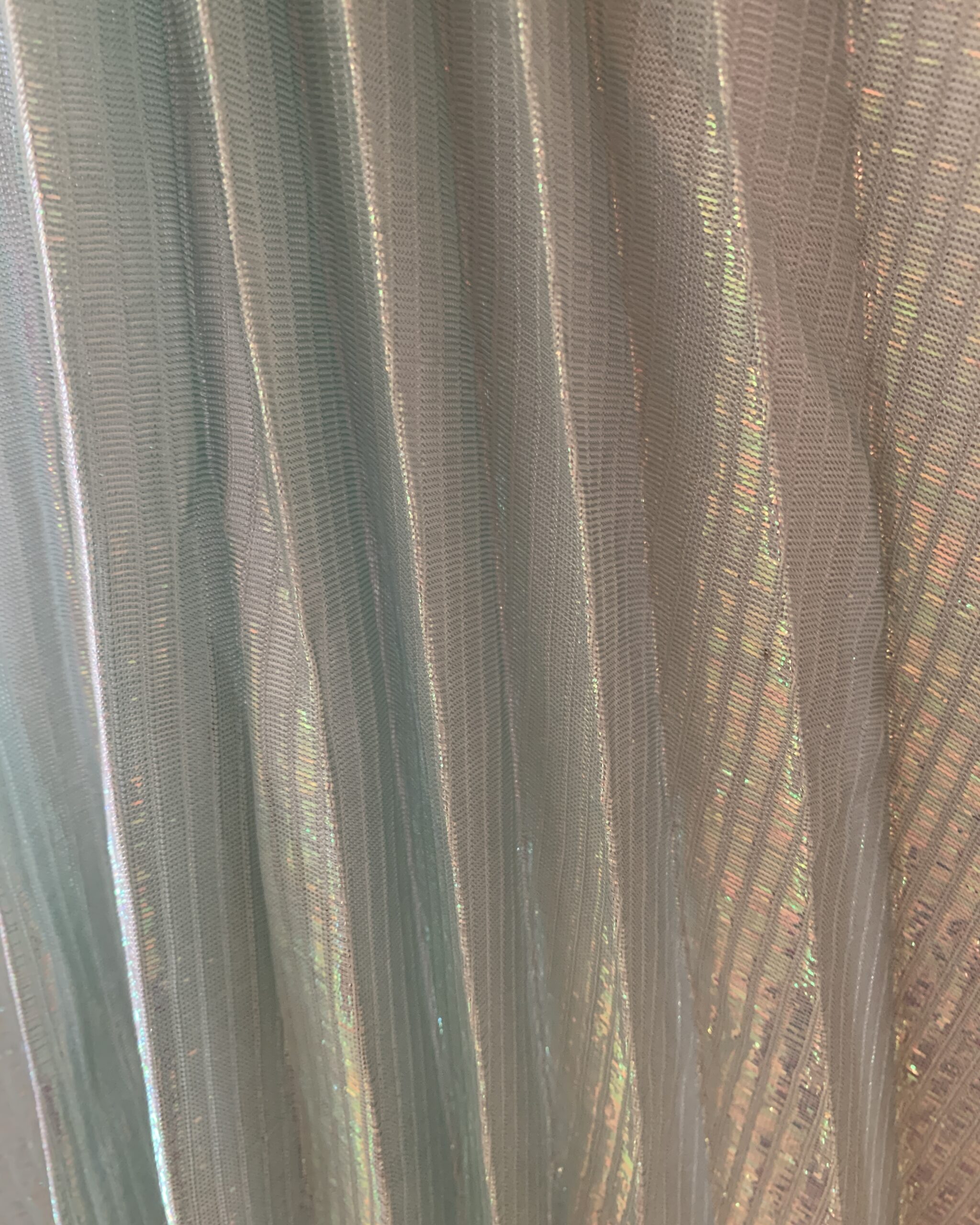Detailed close-up of iridescent seafoam metallic textile with pleated linear texture used in a 1960s New Leaf by Samir evening gown.