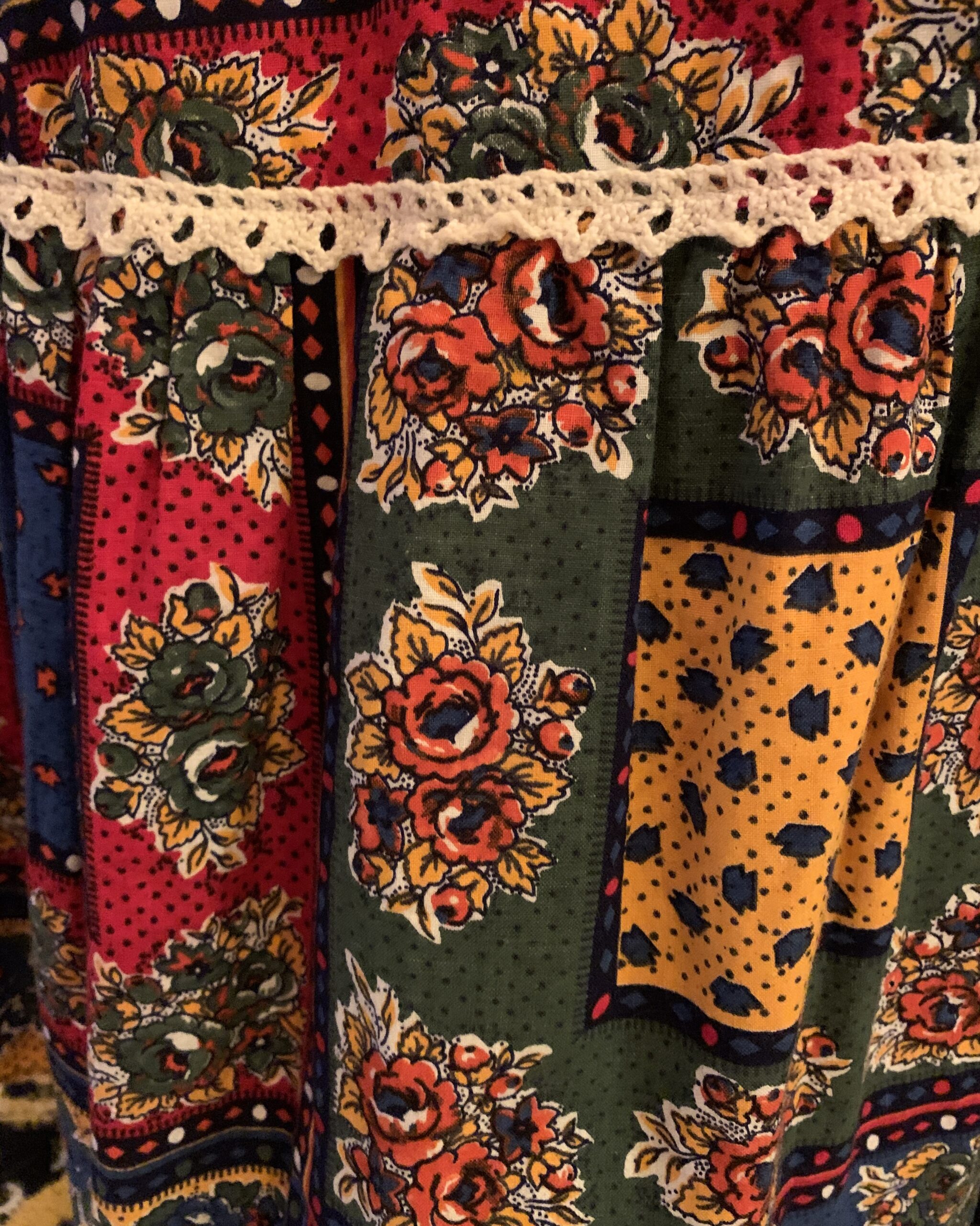 Close-up of colorful patchwork floral print fabric on 1970s prairie dress