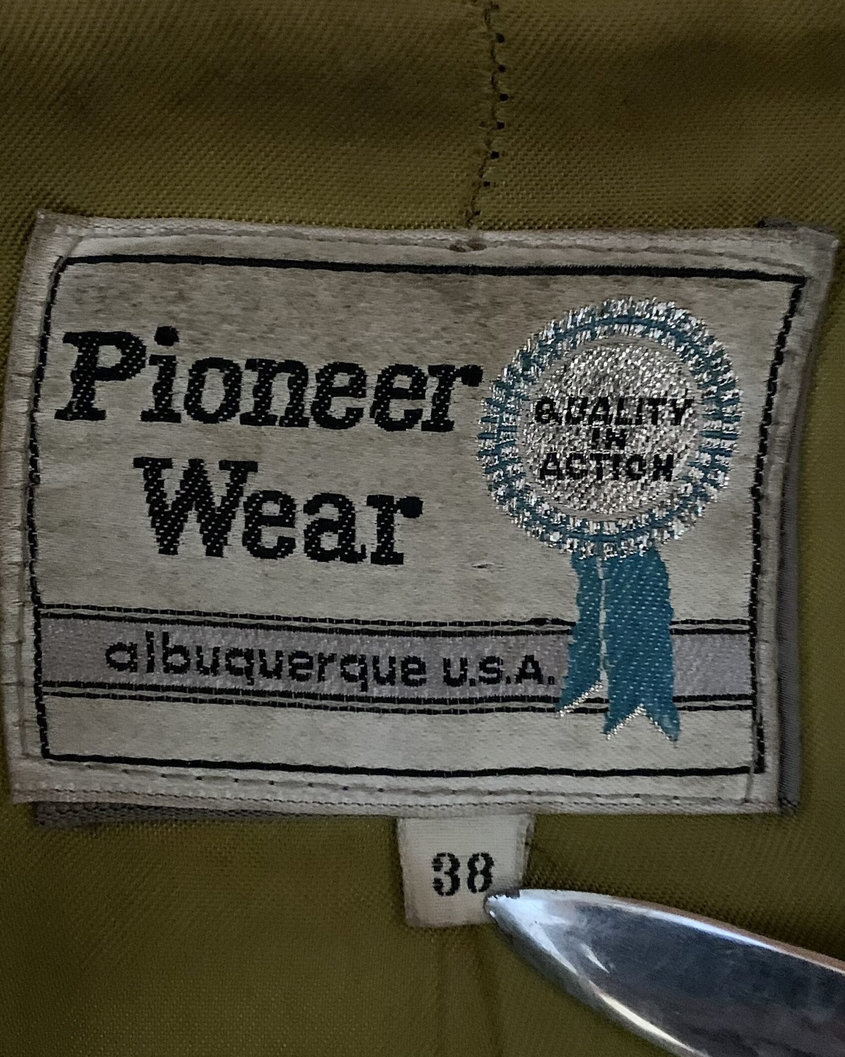 Original Pioneer Wear label reading “Albuquerque U.S.A.” inside a vintage chocolate brown suede Western jacket, size 38.