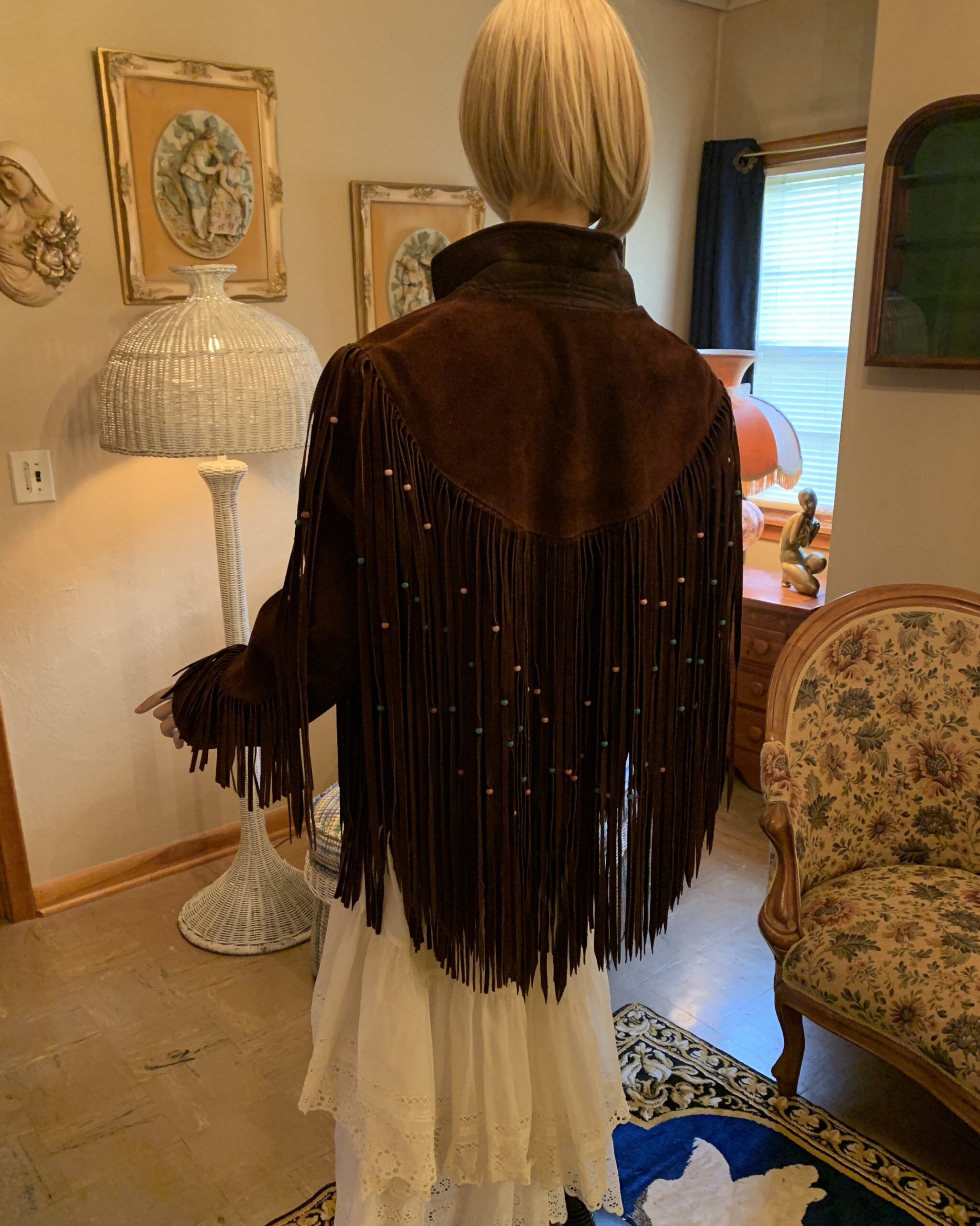 Back view of vintage Pioneer Wear chocolate brown suede jacket featuring a Western yoke with cascading beaded fringe.