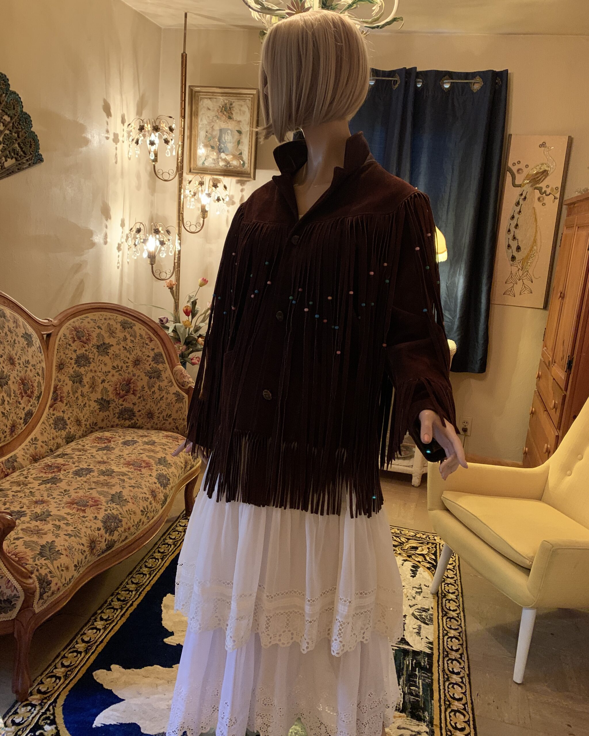 Three-quarter view of vintage Pioneer Wear suede Western jacket highlighting the stand collar, fringe, and beadwork.