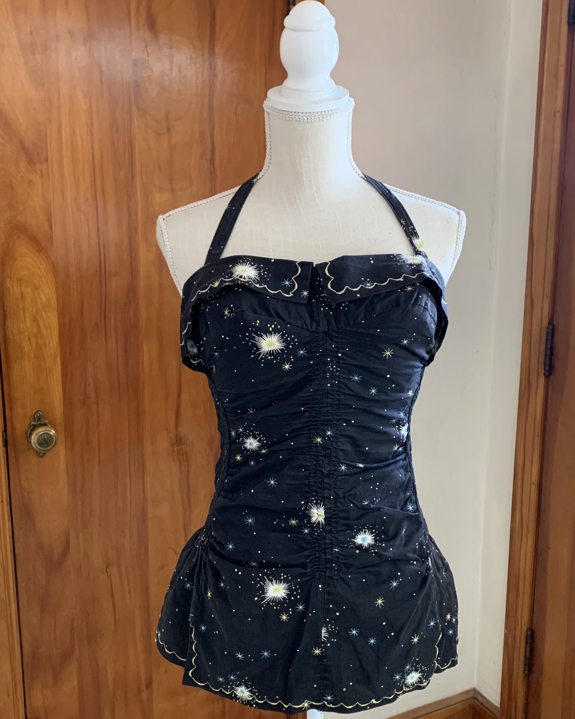 Vintage Sea Nymph black swimsuit with halter neckline, scalloped trim, and allover starburst novelty print.