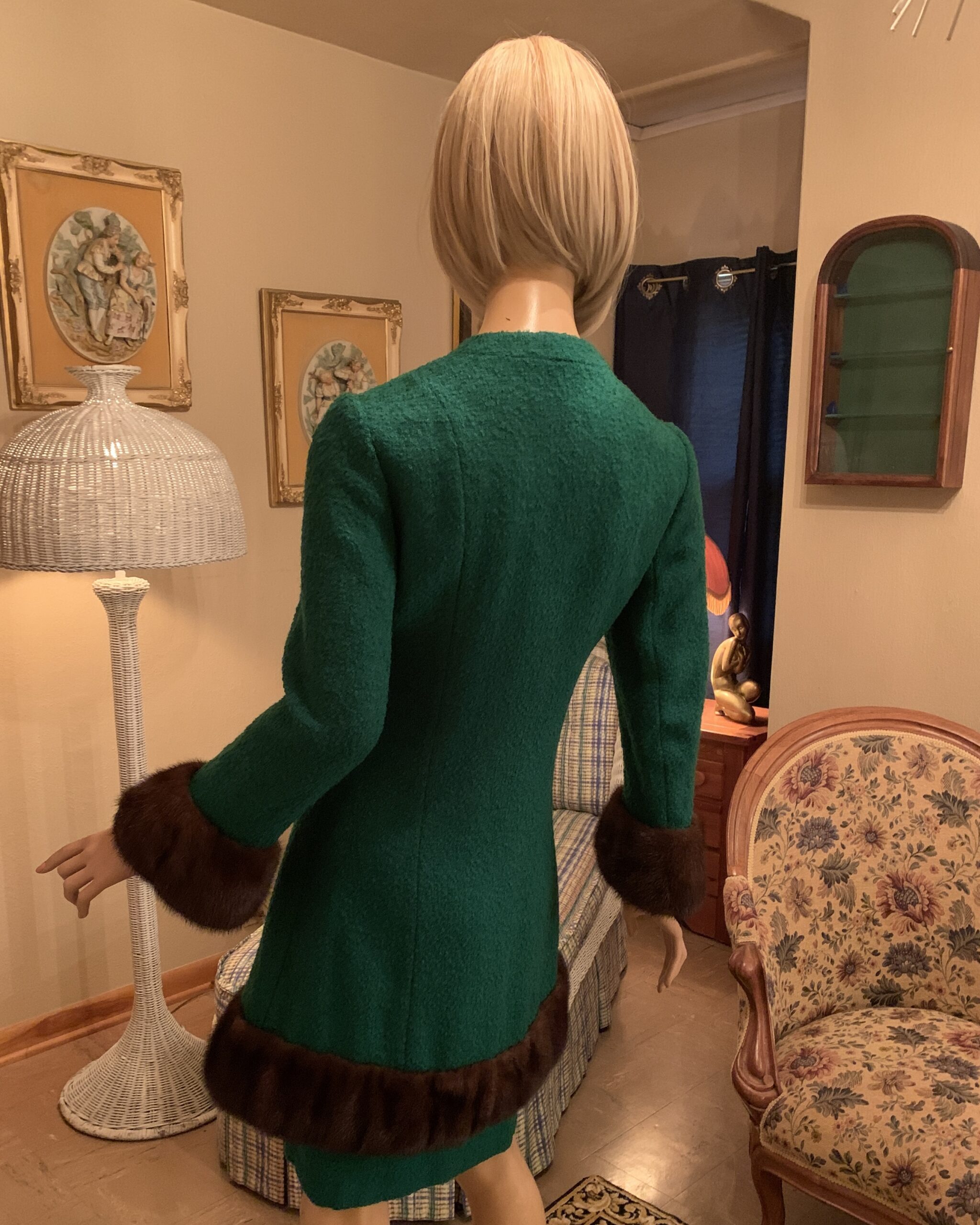 Back view of a vintage Lilli Ann San Francisco emerald green wool coat dress with a sculpted silhouette, bracelet-length sleeves, and dark brown mink fur trim at the hem and cuffs.