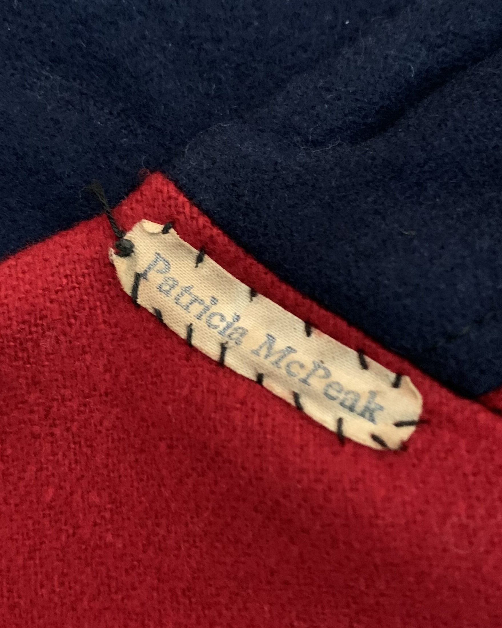 Interior identification tag reading Patricia McPeak attached inside a vintage Snowhite nurse’s cape.