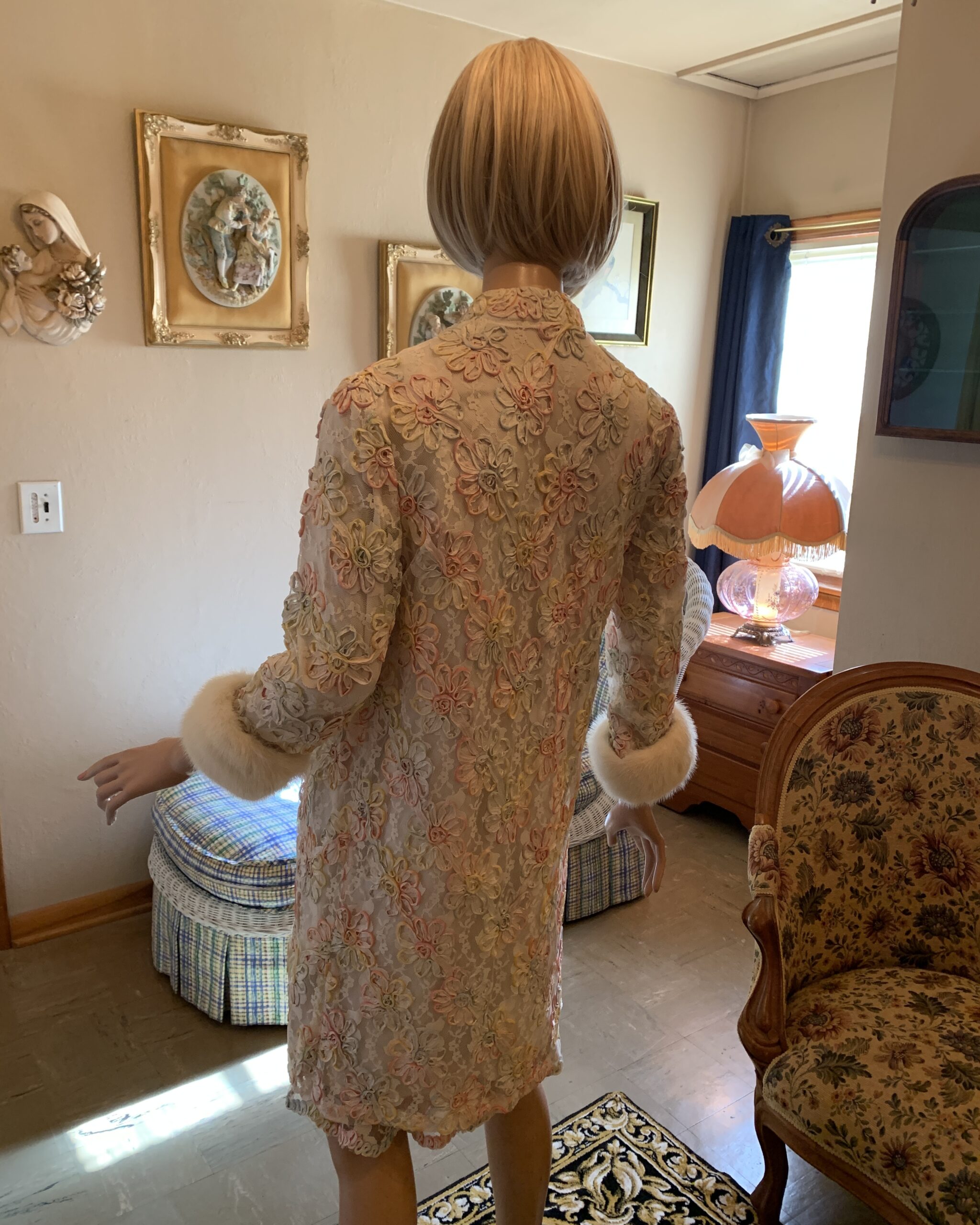 Back view of vintage pastel ribbonwork lace coat with dimensional floral appliqué and white mink-trimmed cuffs.