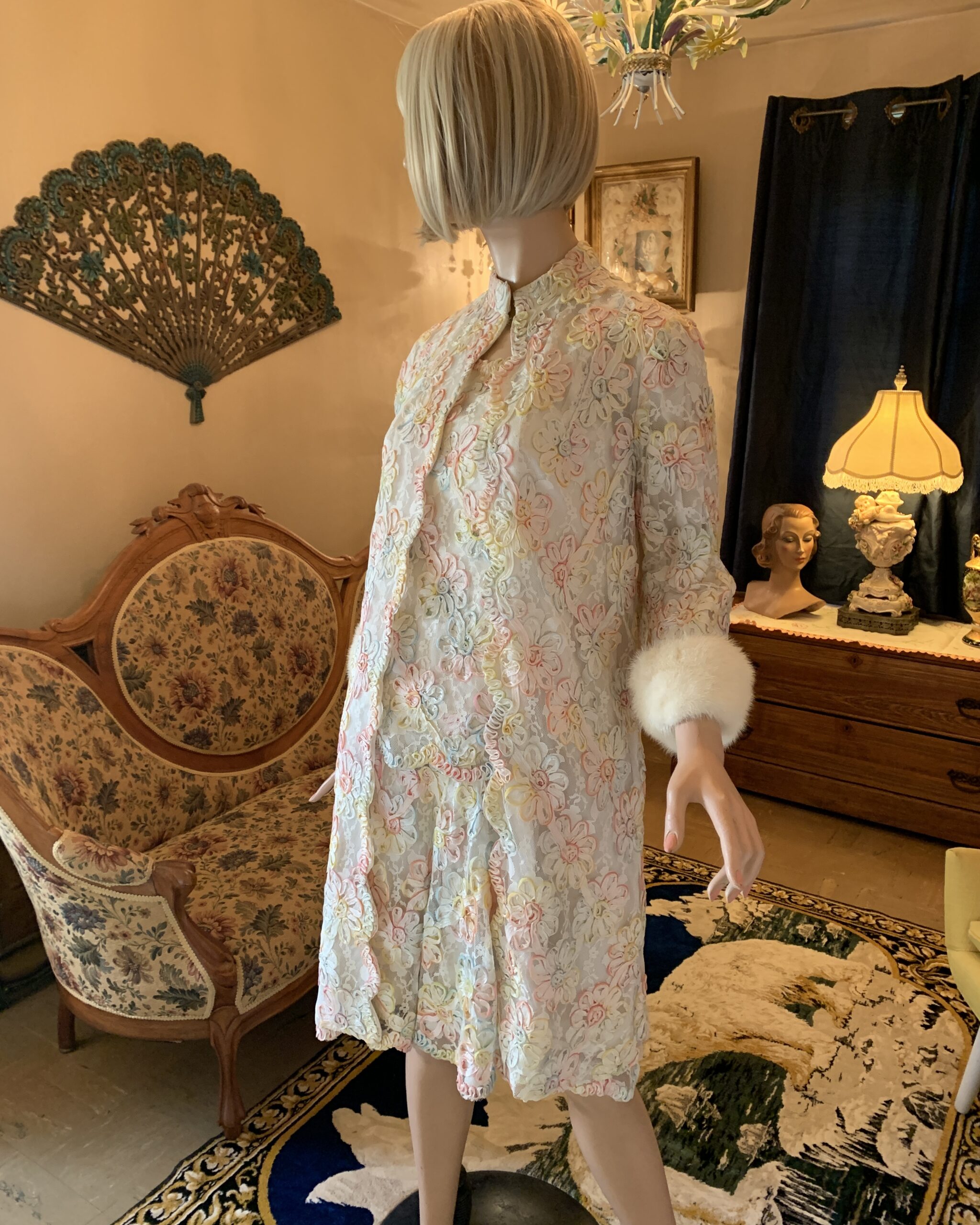 Vintage pastel ribbonwork lace coat and dress ensemble with dimensional floral ribbon appliqué and mink-trimmed cuffs displayed on mannequin.