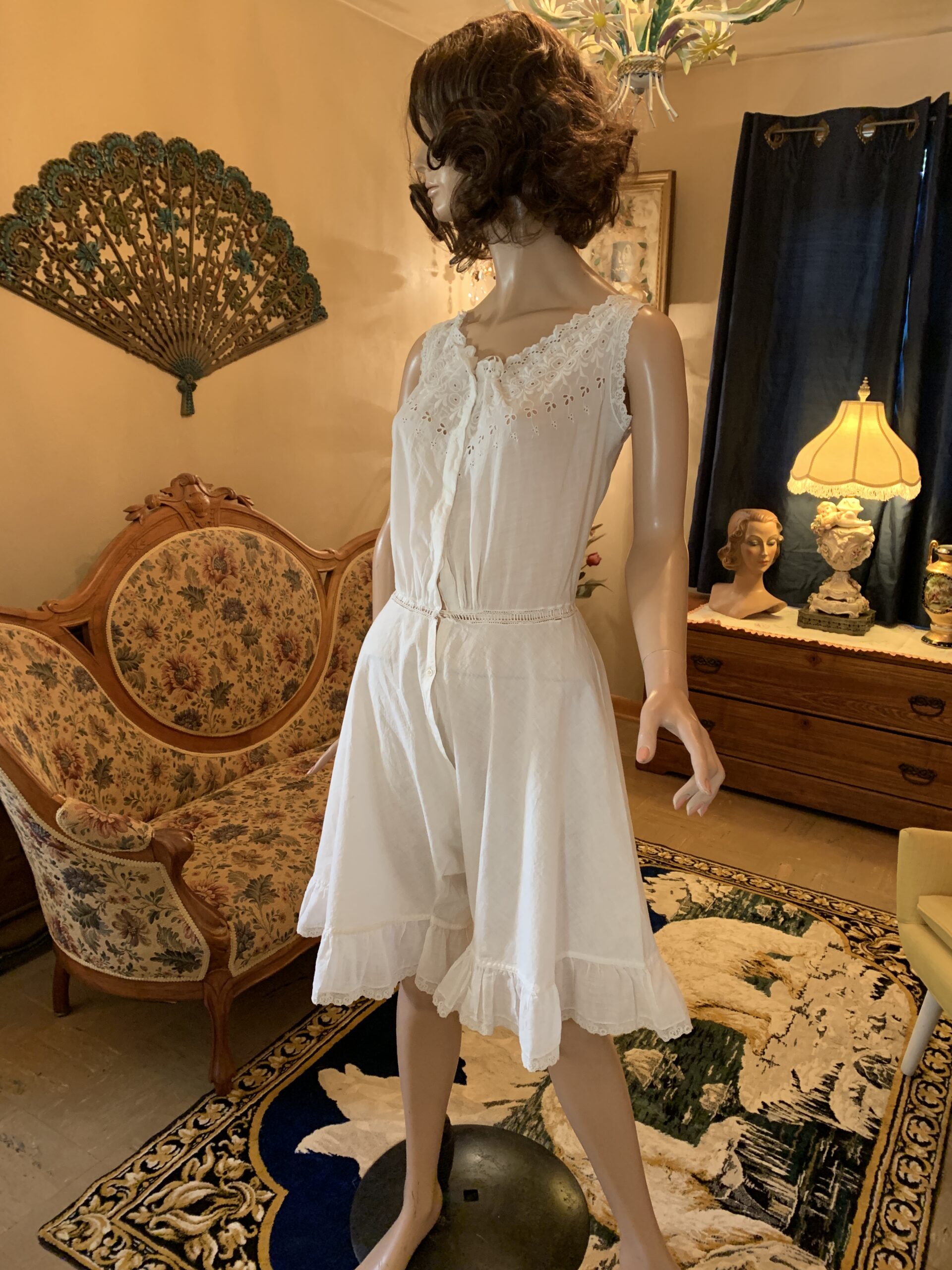 Antique Edwardian white cotton combination step-in displayed on mannequin with embroidered eyelet bodice, satin neckline tie, and divided-leg construction.