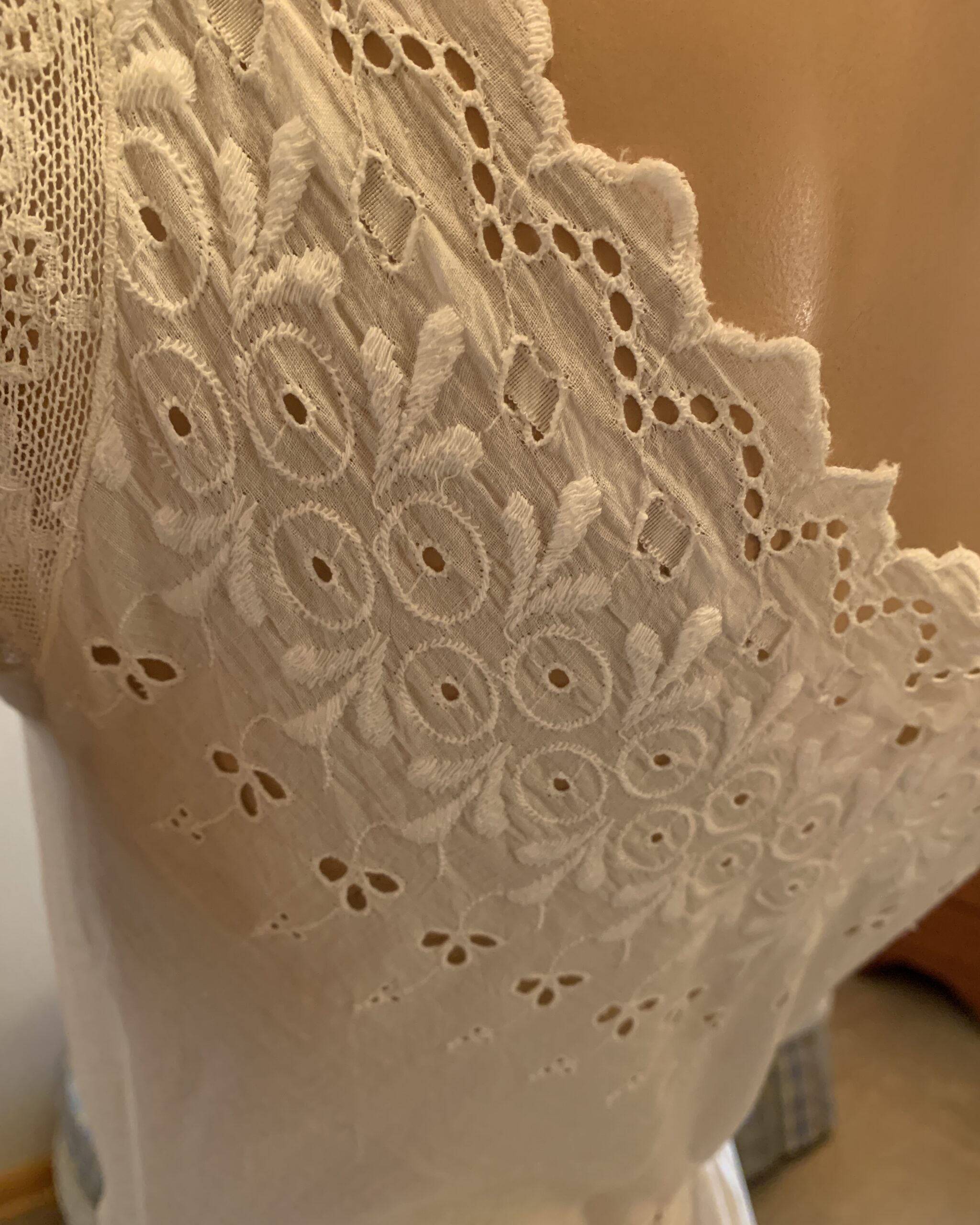 Detailed view of embroidered eyelet work and decorative whitework on antique Edwardian cotton combination garment.