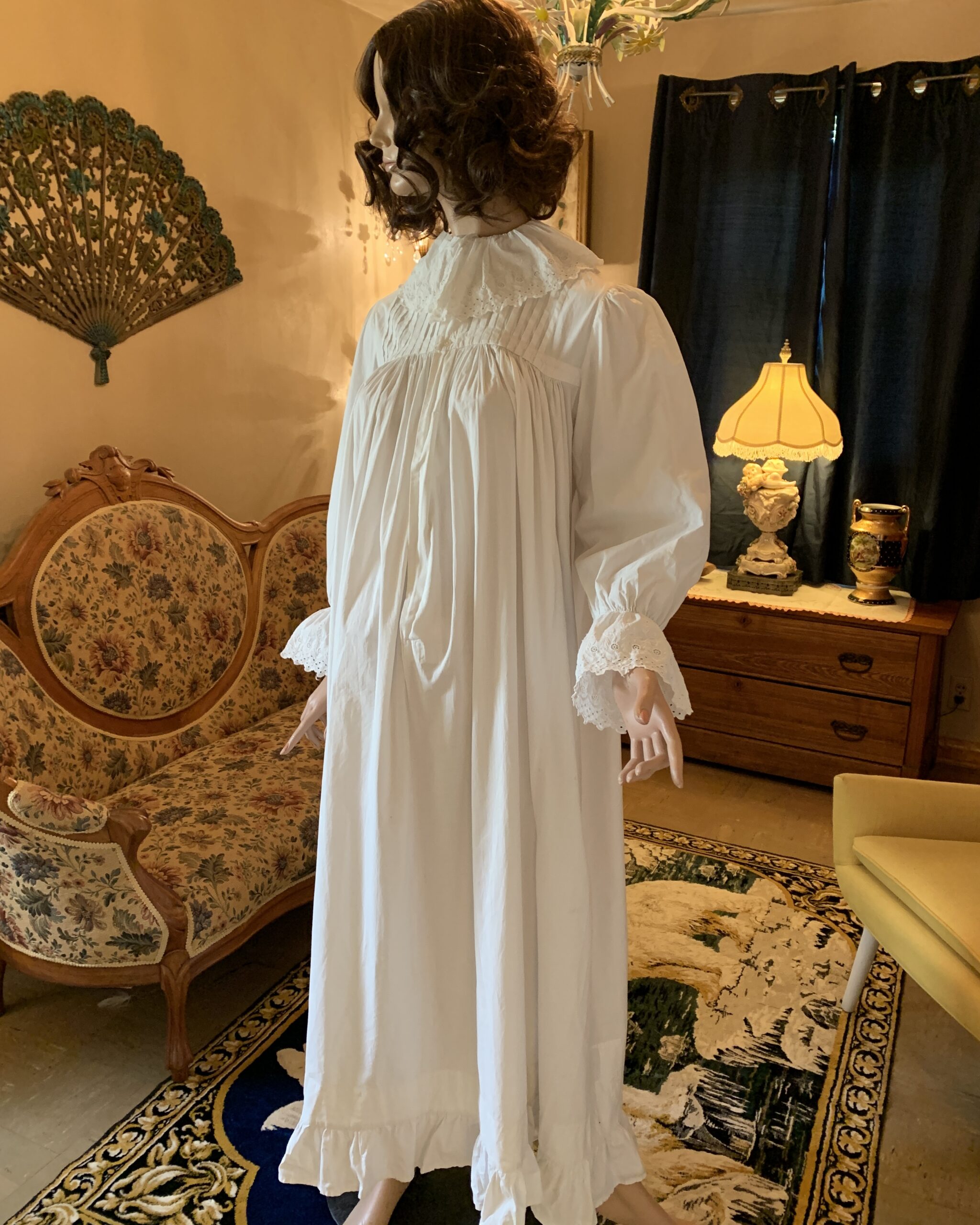 Early 20th-century white cotton nightgown with embroidered whitework collar, pintucked yoke, and full gathered sleeves.