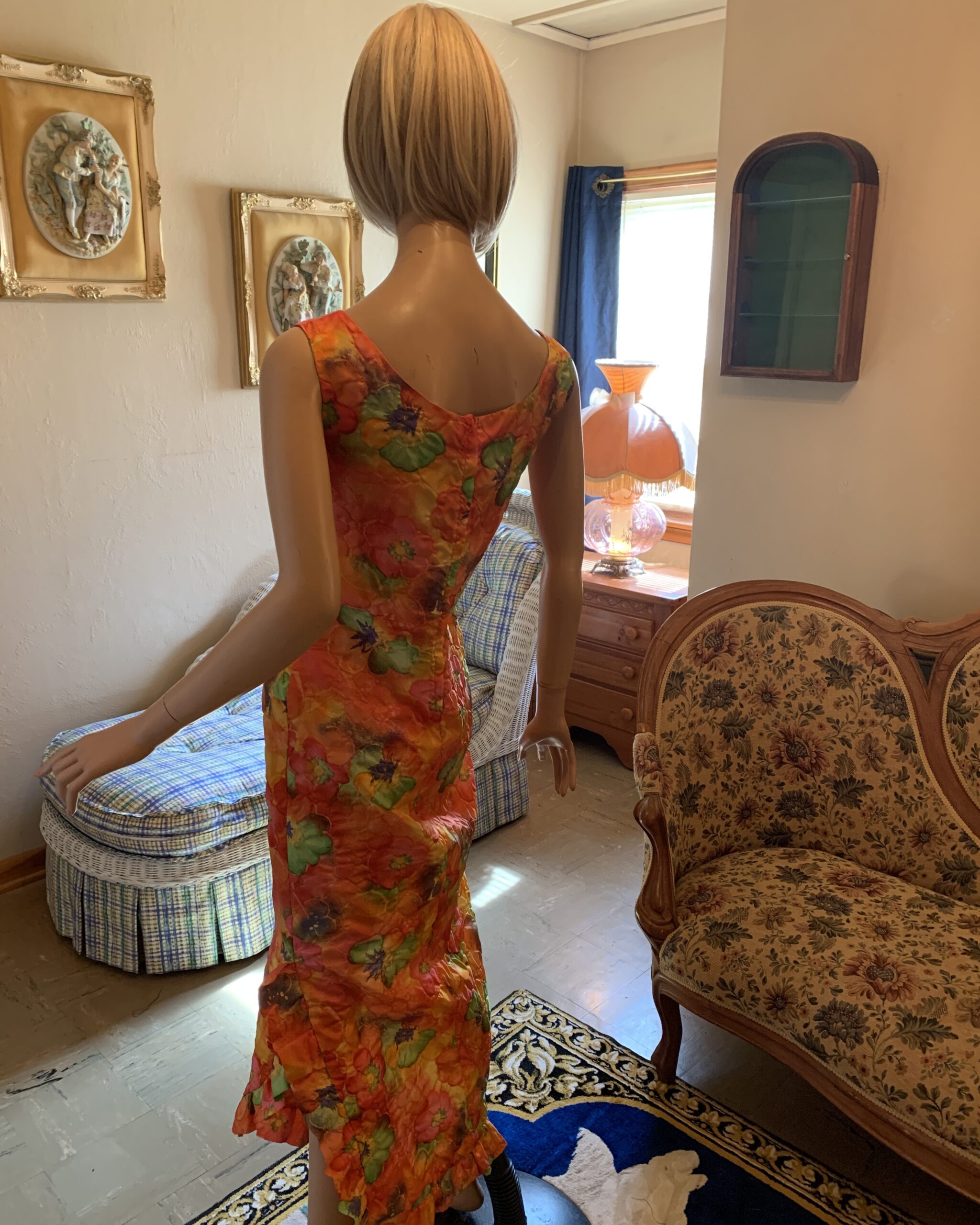 Rear view of a 1960s floral resort maxi dress with a fitted silhouette and back zip closure.