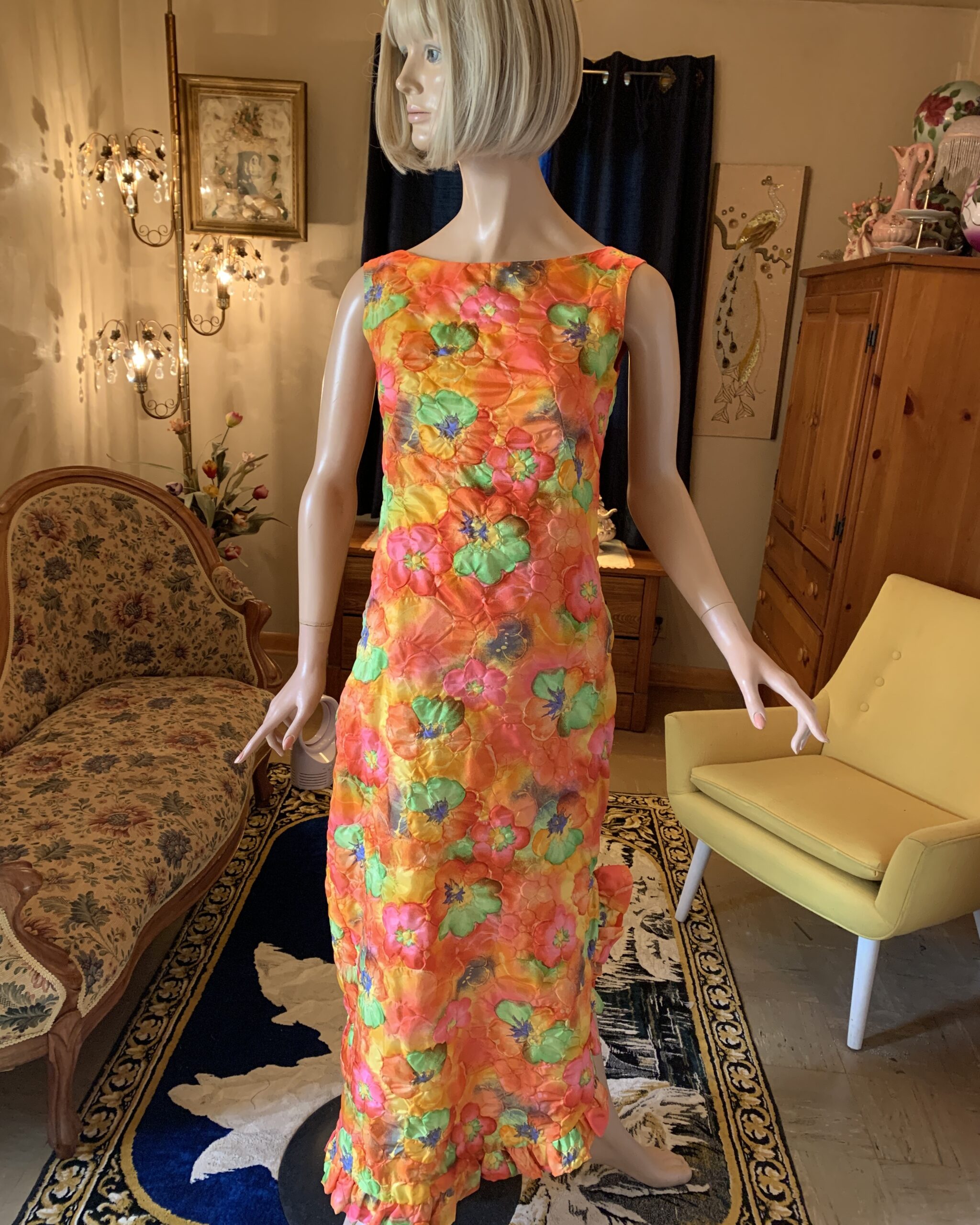 1960s psychedelic floral resort maxi dress in vibrant shades of orange, pink, yellow, and green displayed on a mannequin.