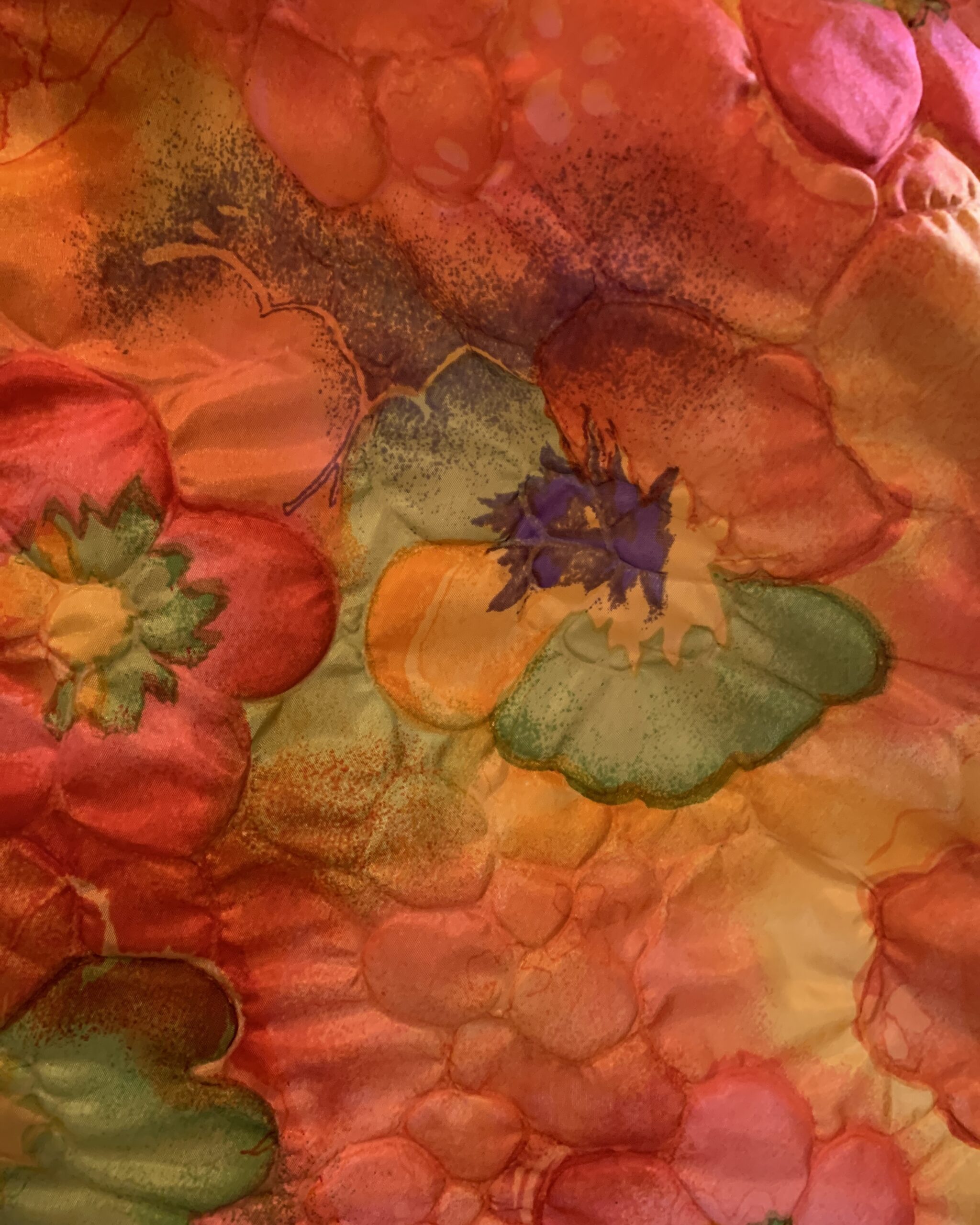 Detail of the watercolor-style floral print in orange, pink, yellow, green, and violet tones on a vintage resort dress.