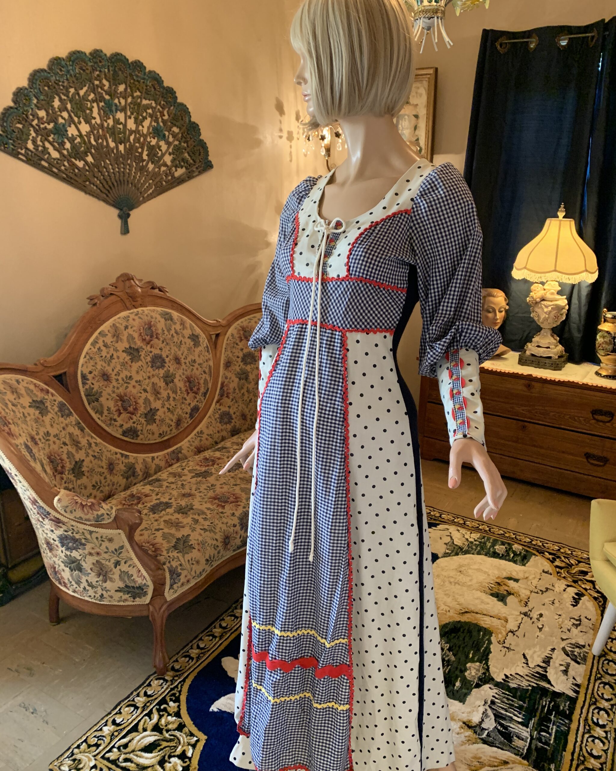 Early 1970s Gunne Sax by Jessica prairie dress featuring navy gingham panels, white polka-dot fabric, puff sleeves, and colorful ric-rac trim.