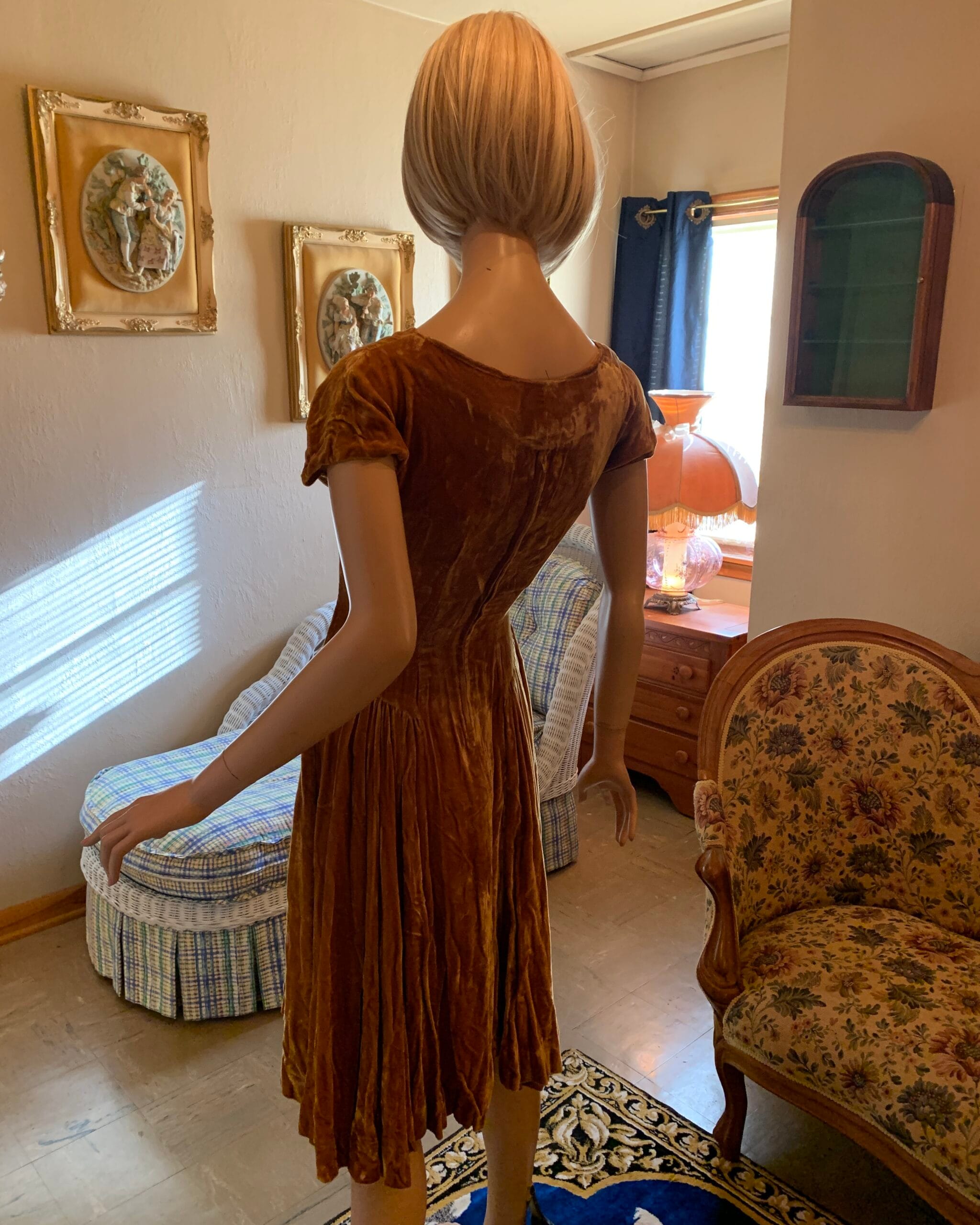 Back view of a vintage golden velvet party dress with a fitted silhouette and full gathered skirt.
