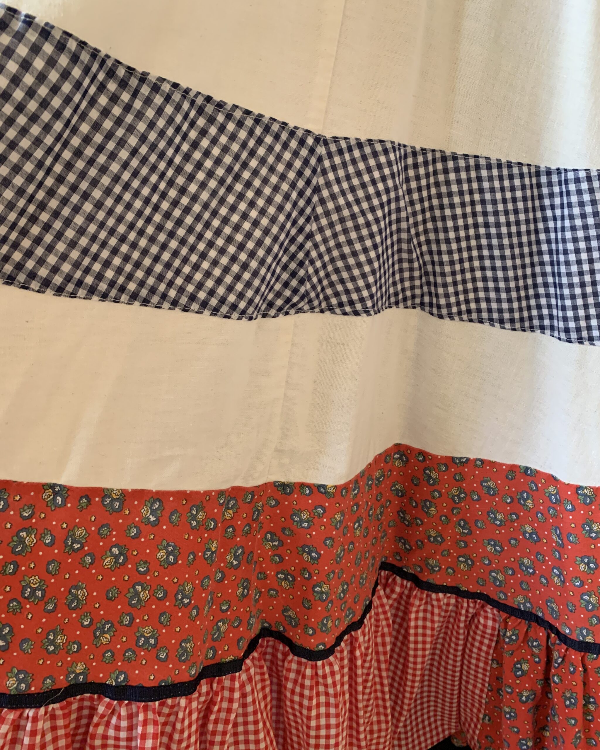 Detail of tiered Gunne Sax skirt with alternating gingham, floral calico, and white cotton panels.