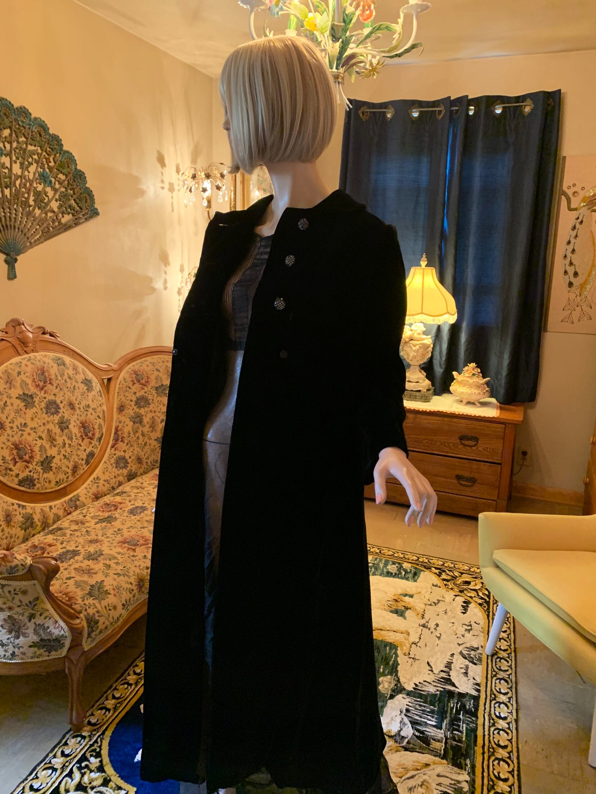 Black velvet opera coat shown partially open, revealing the satin lining and elegant full-length silhouette.