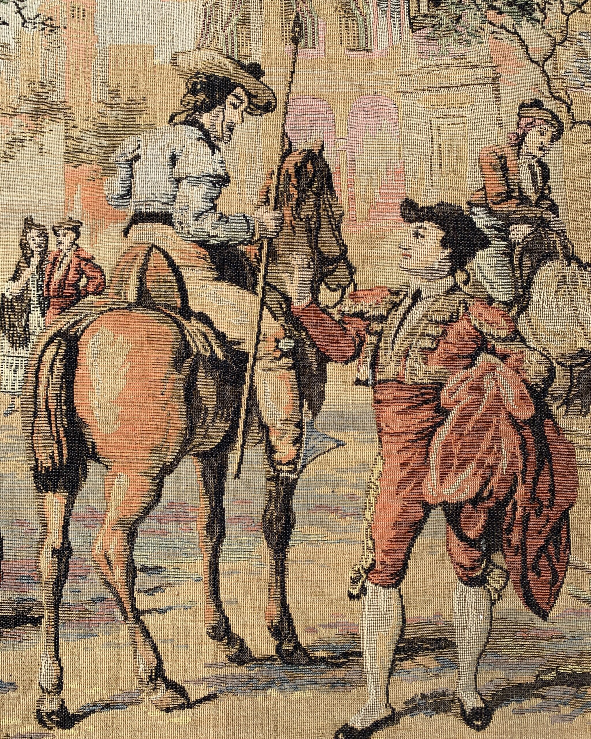 Vintage tapestry detail featuring horse and rider with elegantly dressed figures in a romantic Spanish courtyard scene.