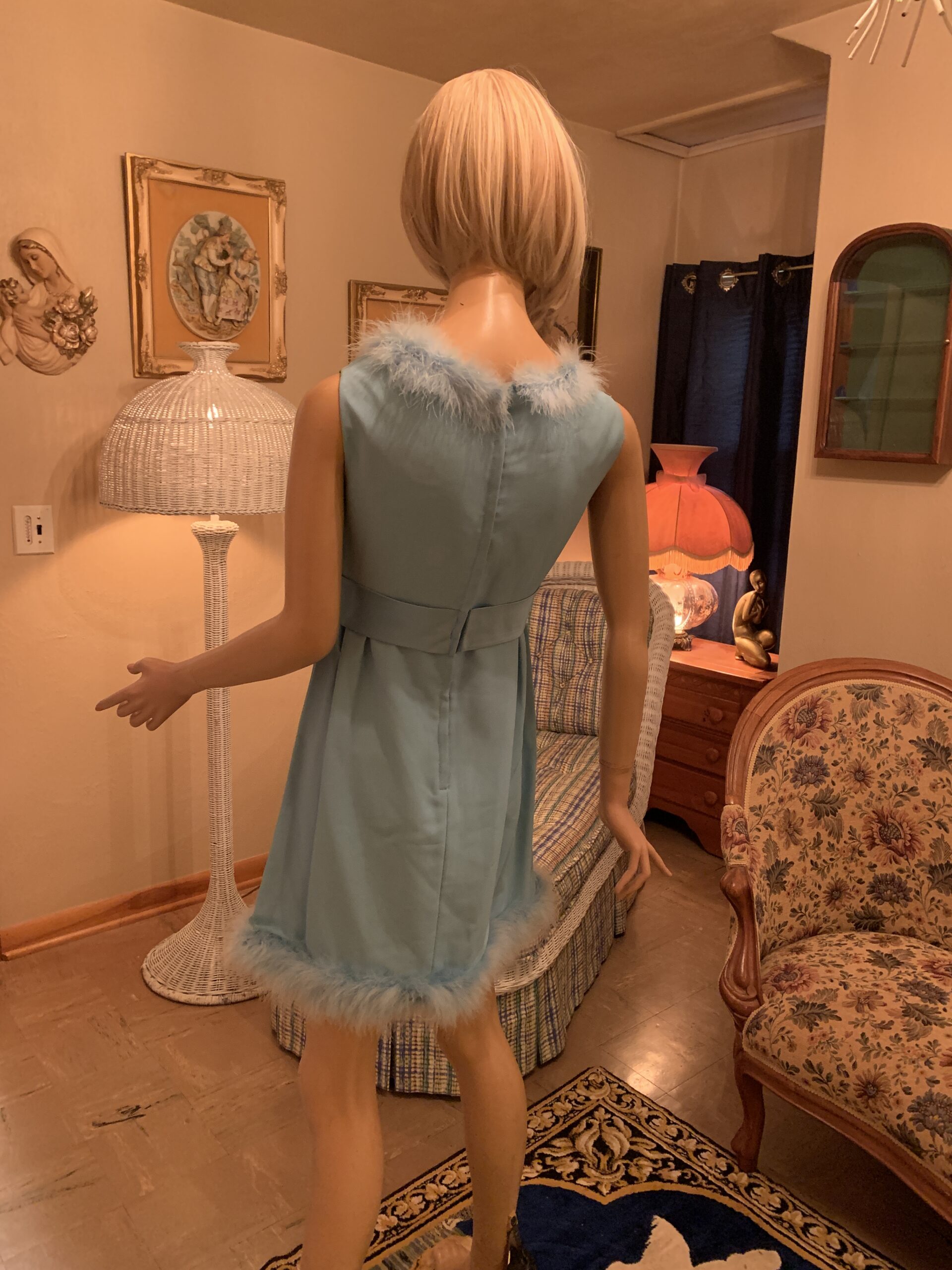 Back view of a vintage 1960s robin’s egg blue cocktail dress with marabou feather neckline, back zipper closure, and feather-trimmed hem.